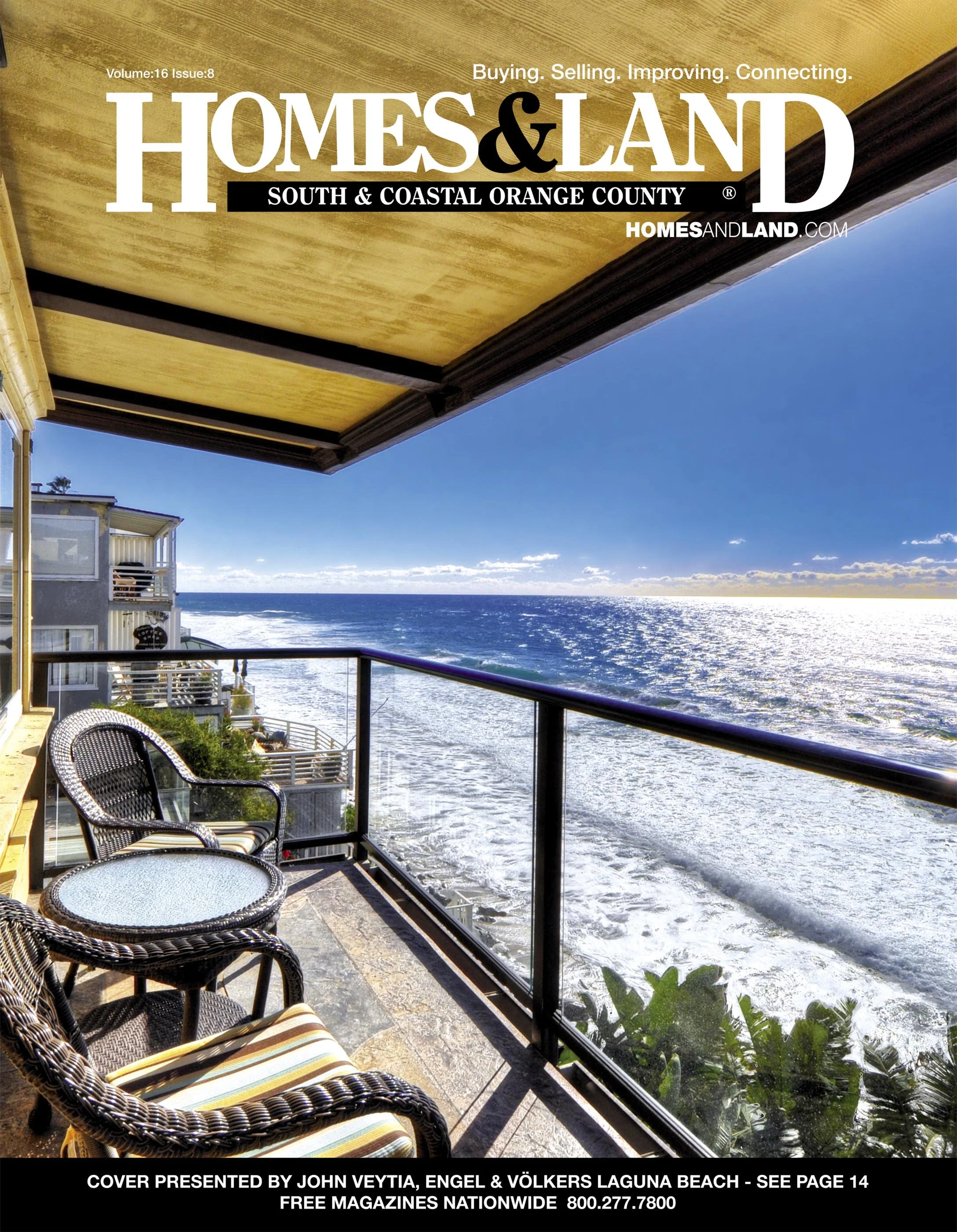 Beachfront balcony with chairs, overlooking ocean waves, under a yellow ceiling, with neighboring buildings nearby.