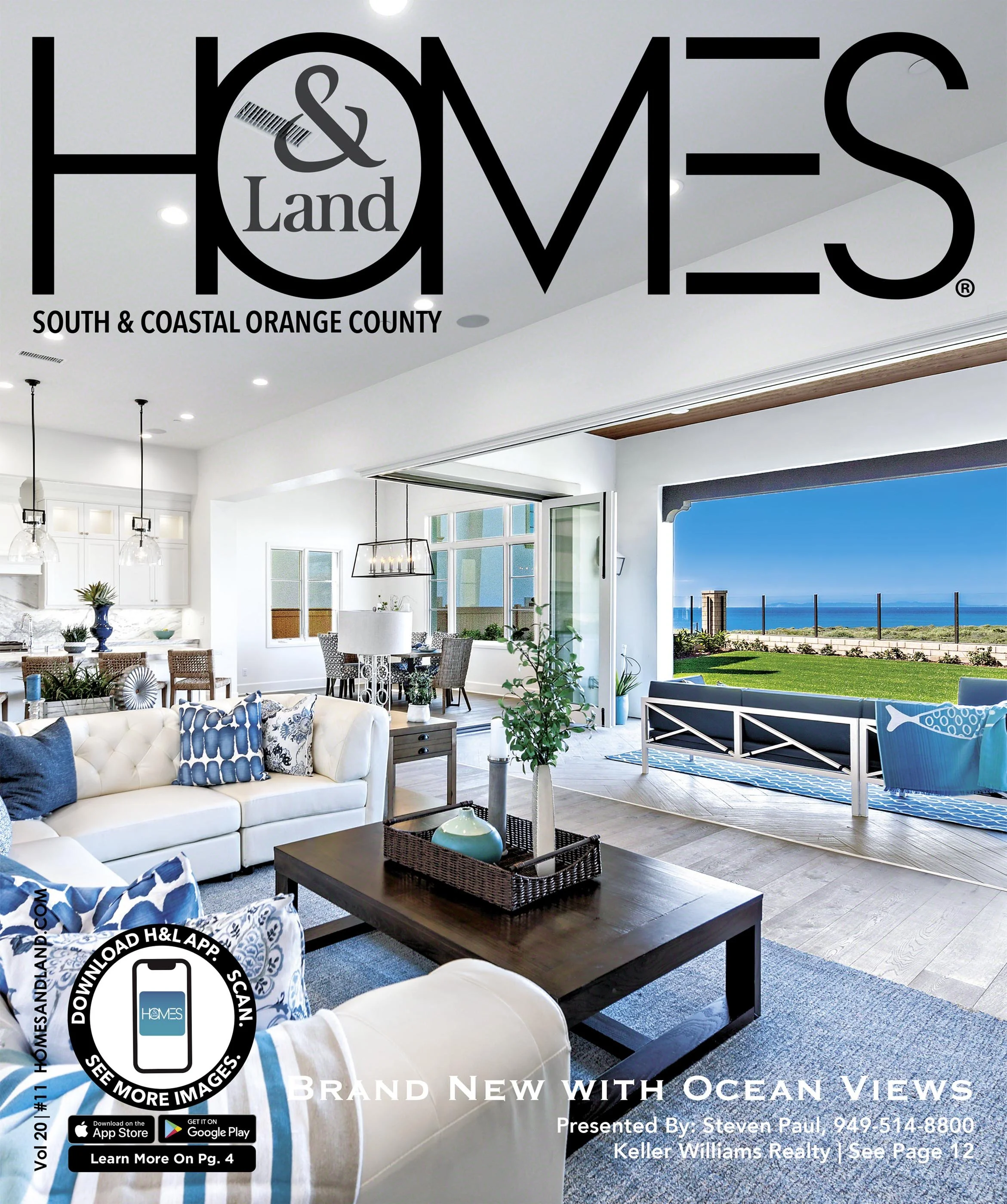 Cover of Homes & Land magazine featuring a bright coastal living room with ocean views, white sofa, blue and white pillows, coffee table with plant, open kitchen and dining area, and large windows showing ocean and green lawn.