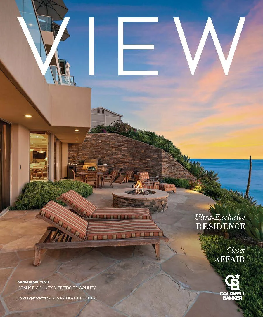 Luxury outdoor patio with striped cushioned lounge chairs, a fire pit, and ocean views at sunset