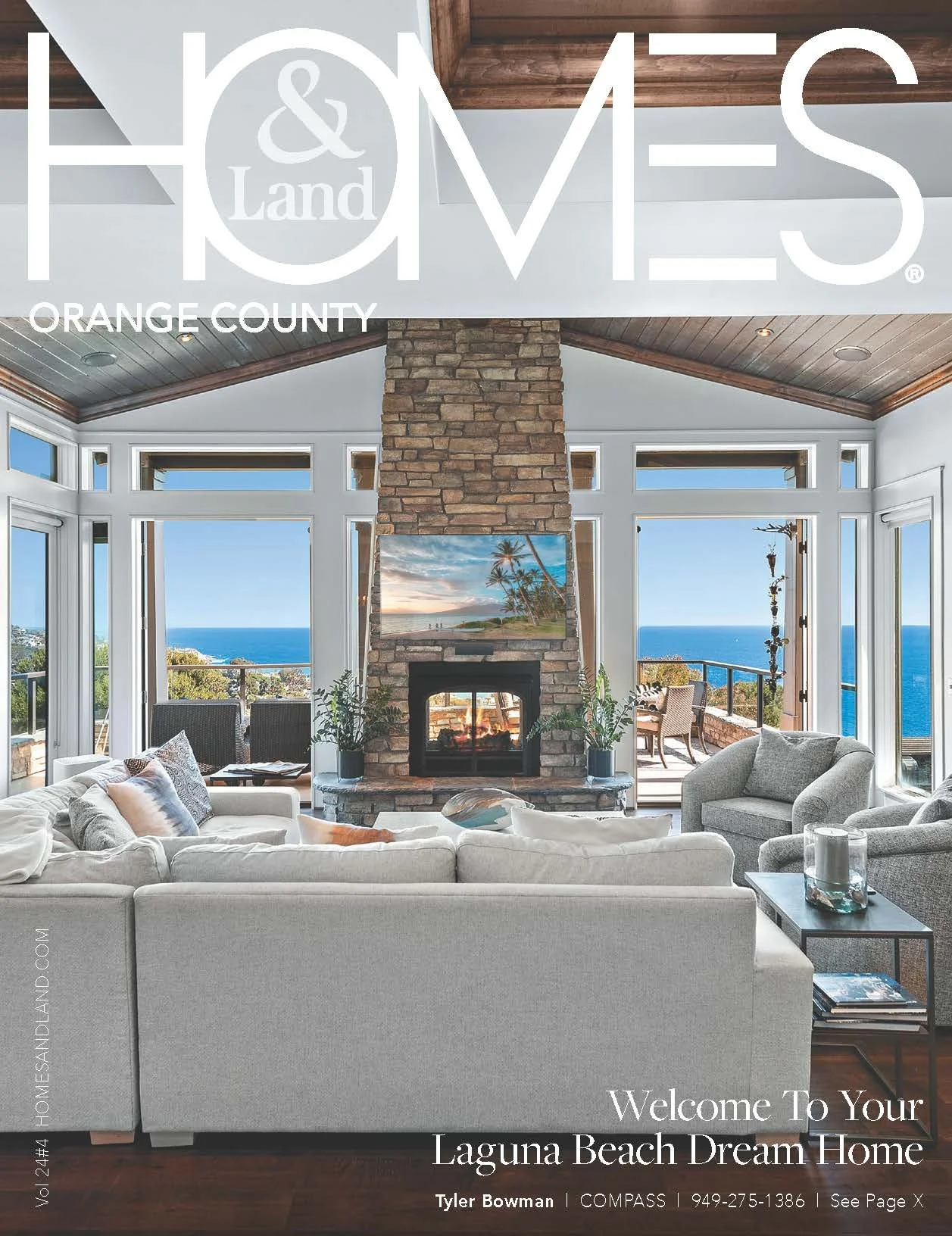 Bright living room with large windows, ocean view, stone fireplace, white sofa, and outdoor deck.