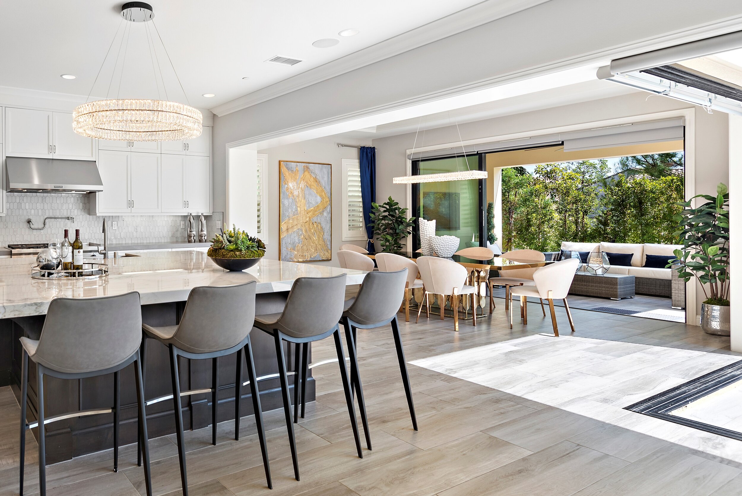 Open-concept kitchen and dining area with sliding glass doors leading to outdoor patio, modern furnishings, and natural light.
