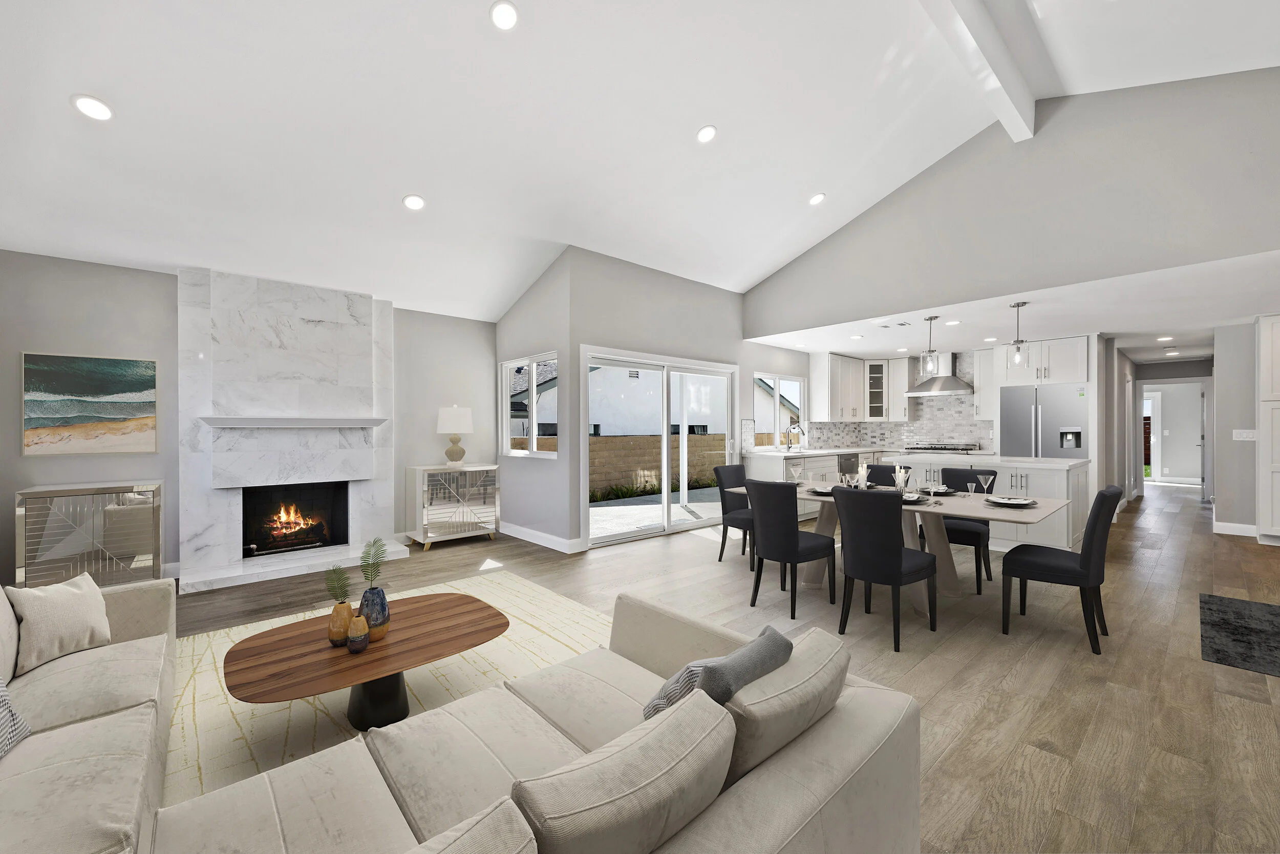 Open-concept living room and kitchen with white walls, a fireplace, modern furniture, a dining table, and large sliding glass door leading to a backyard.