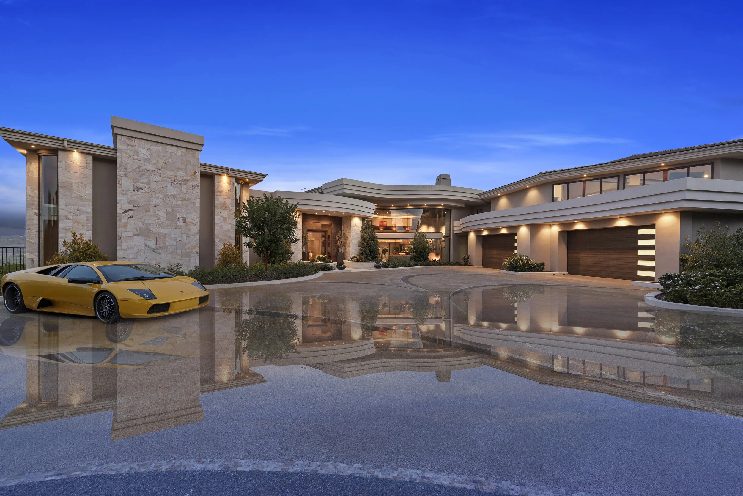 Luxury modern house with large driveway, yellow sports car parked on wet surface, and a clear evening sky.