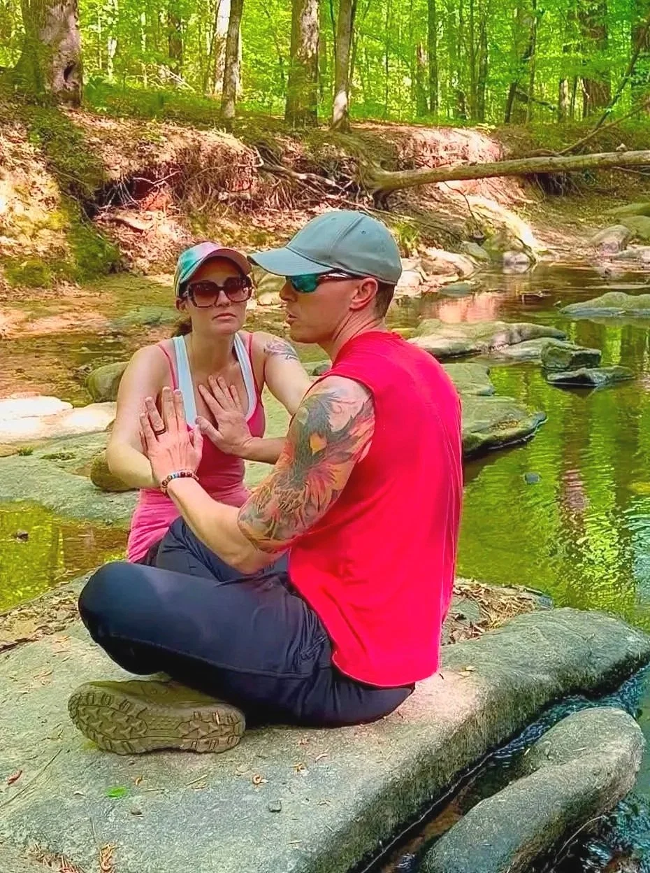Tieterious and Seraphina Skye practicing conscious connection and meditation together outdoors in nature, Entwined Breath couples wellness experience
