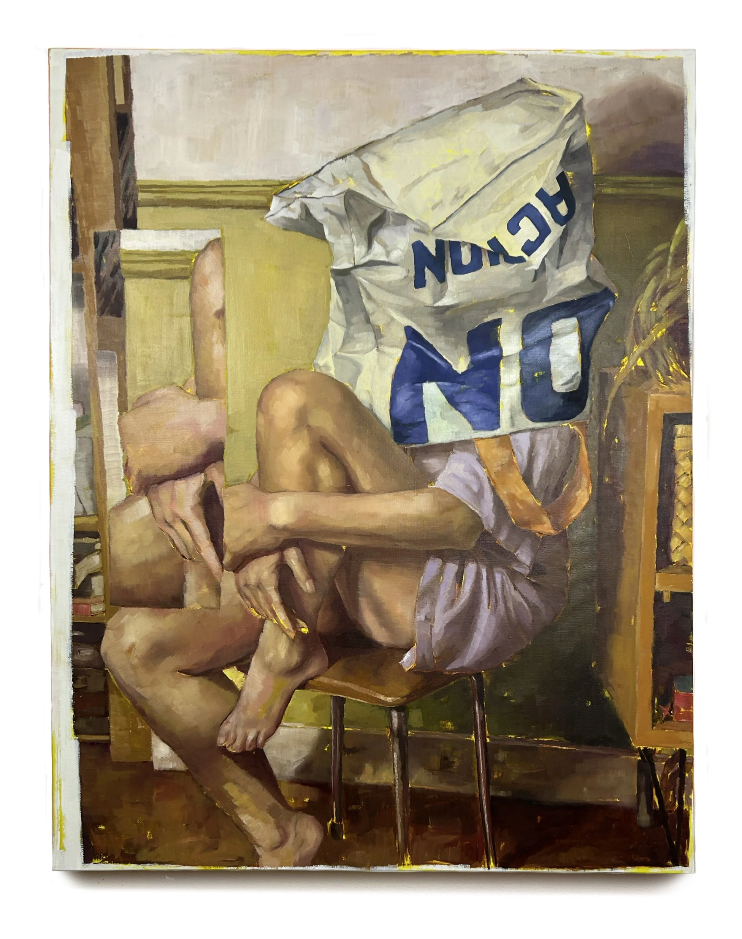 A person sitting on a chair with their legs crossed, holding a phone, and wearing a large paper bag on their head labeled "NO NUCLEAR".