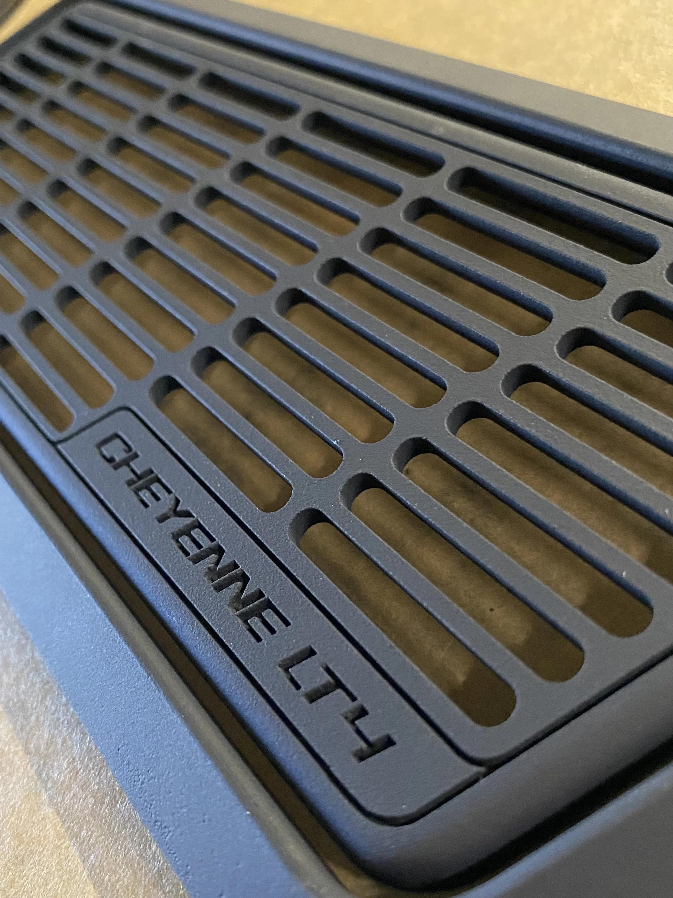 Close-up of a black grill cover with the text 'CHEVROLET 11' embossed on it.