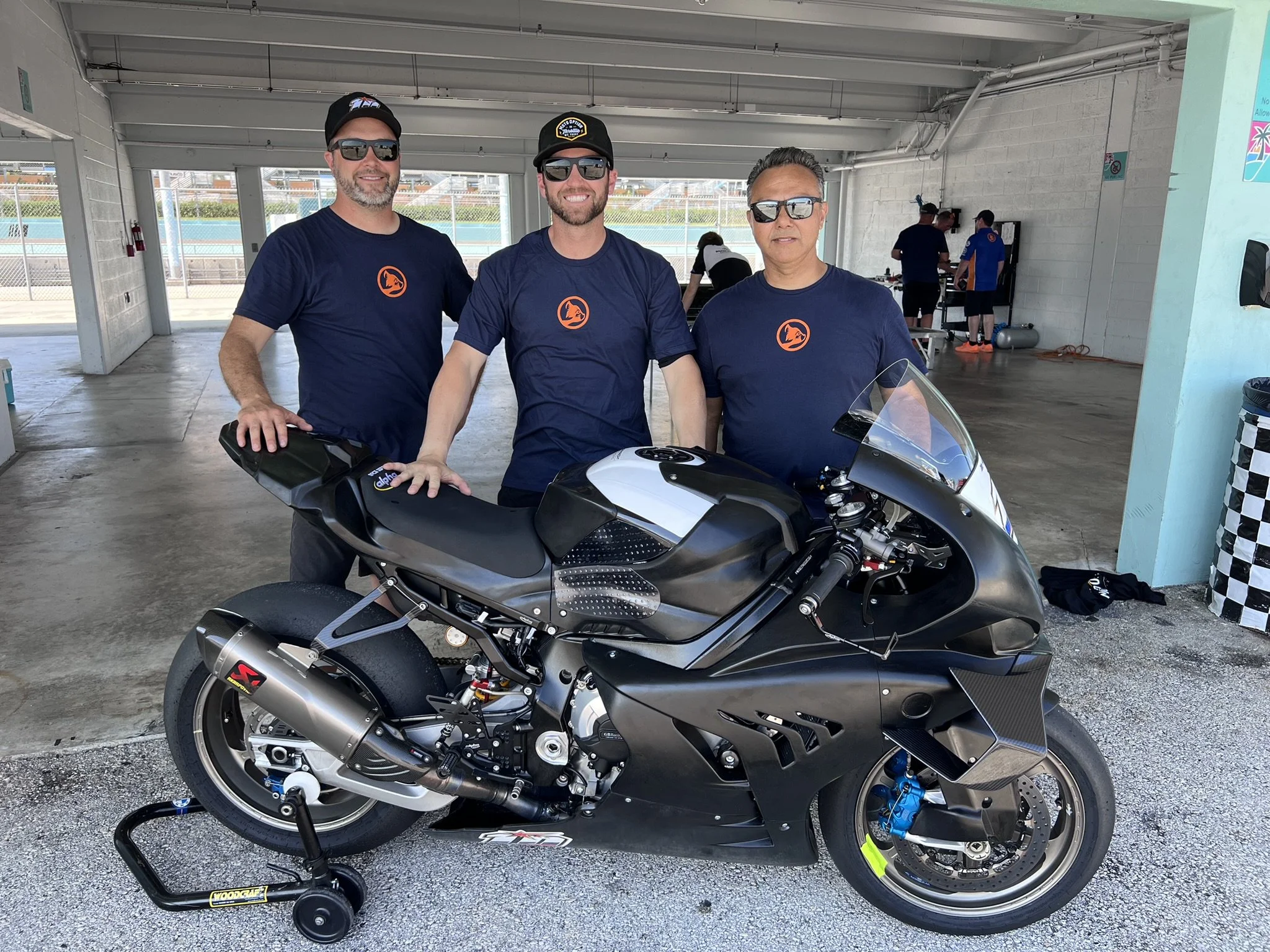 OrangeCat Racing’s Travis Wyman is flanked by his crew chief Joel Martens (left) and mechanic Alex Torres (right). Wyman will ride one of the team’s two BMW M 1000 RRs in the 2024 MotoAmerica Stock 1000 Championship.