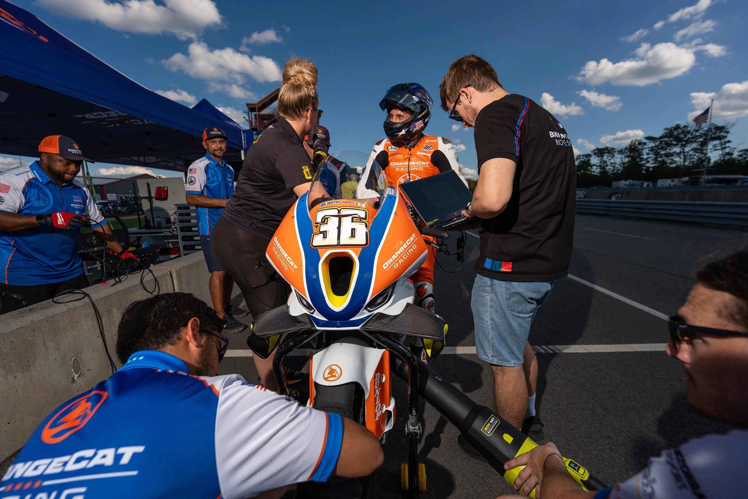 OrangeCat Racing pit crew servicing Jayson Uribe’s BMW M 1000 RR in the hot pit during a MotoAmerica race weekend.