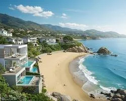 Beach with sandy shoreline, rocky outcrops, ocean waves, and hillside homes under a partly cloudy sky.