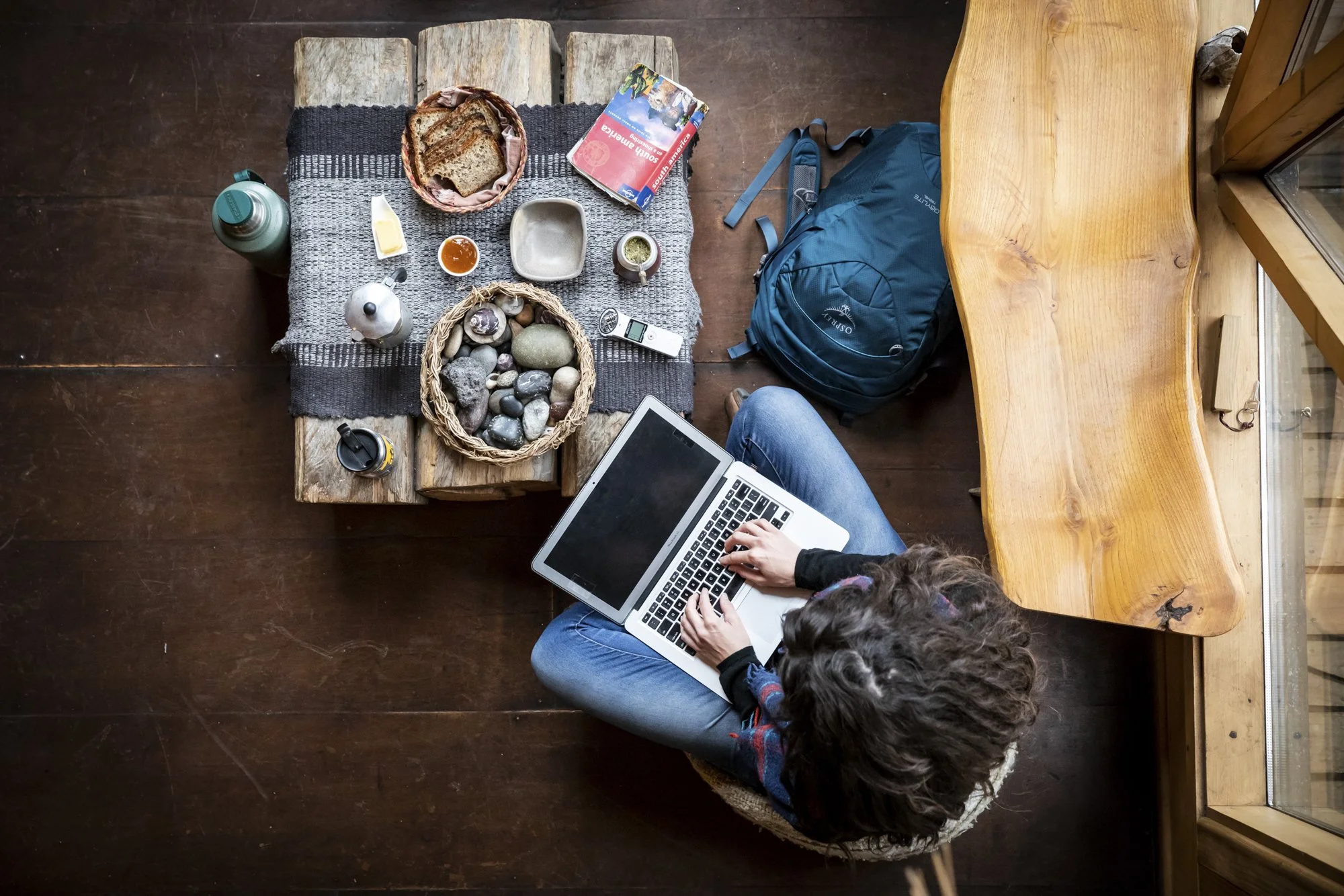 Top-down shot of a woman using a laptop in Patagonia, Chile during an Osprey travel assignment, photographed by Fieldborn Creative.