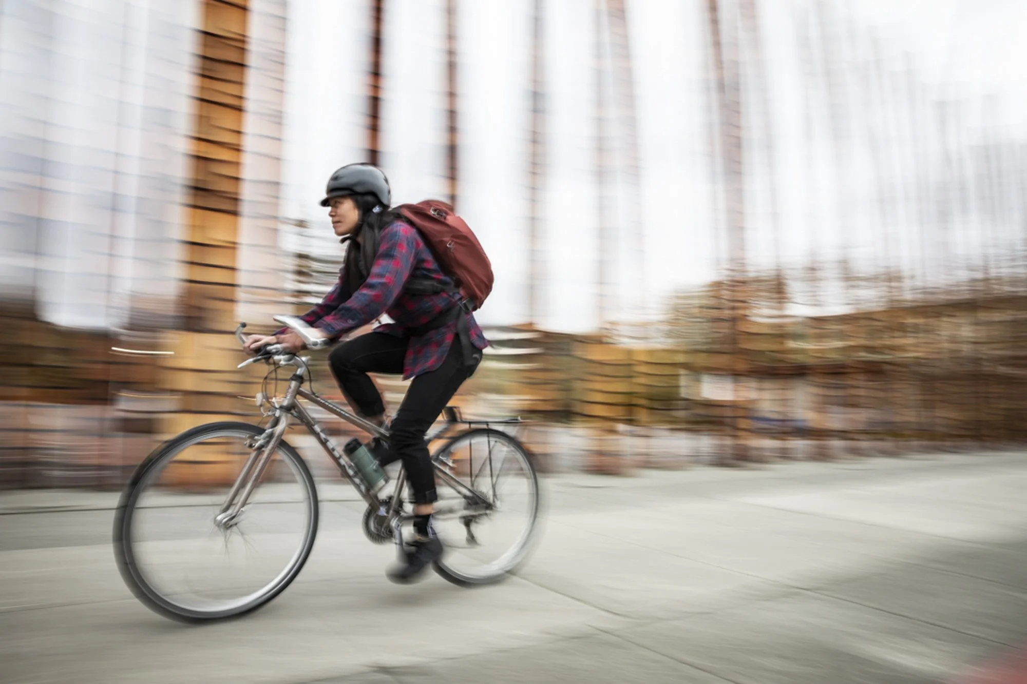 Woman bike commuting in downtown Seattle during an Osprey assignment, photographed by Fieldborn Creative.