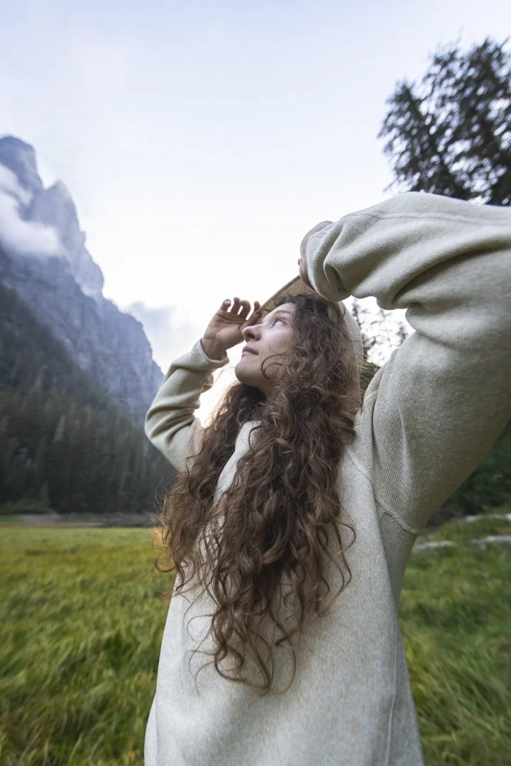 Portrait of a young woman in a sweater in the mountains of Washington State, photographed on assignment for Stio by Fieldborn Creative.