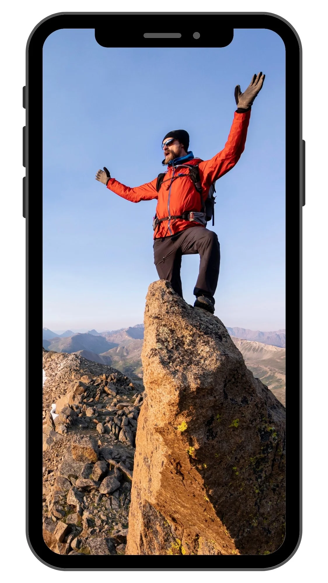 Man standing on rock near mountain summit in Colorado, photographed on assignment for Osprey Packs by Fieldborn Creative