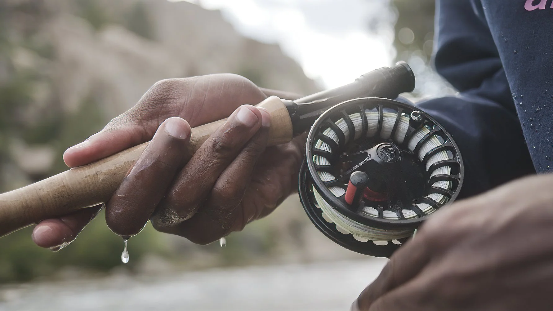 Close-up of Eeland Stribling’s hand on a fly rod while fishing near Salida, Colorado for the Protect Our Winters Punchline film, produced by Fieldborn Creative.