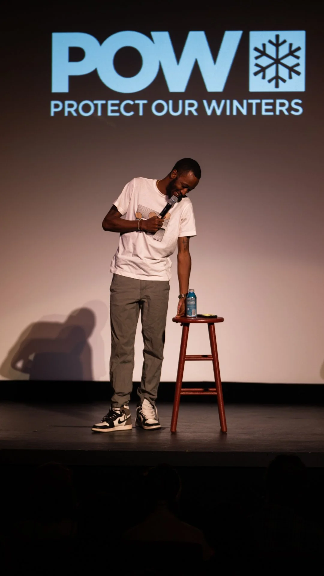 Eeland Stribling on stage at Protect Our Winters StokeFest in Bozeman, Montana during the Punchline film release, photographed by James Burchmore.