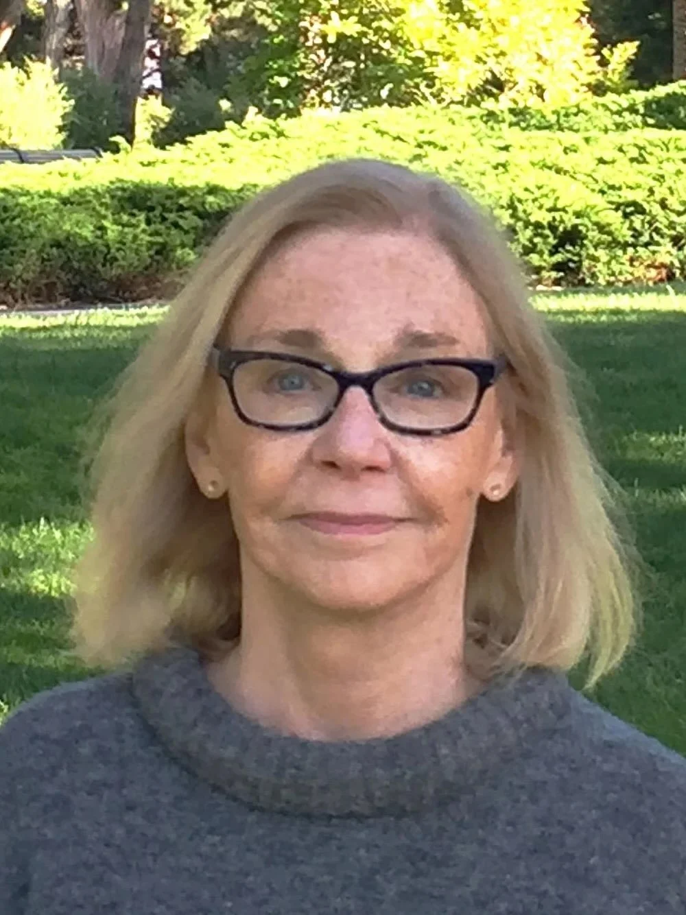 Headshot of dr. martha williams with a green field in the background.