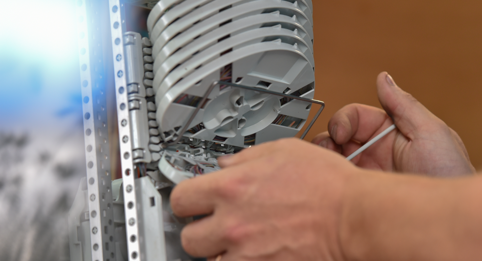 Die Hände eines Skyber-Technikers bei der Reparatur oder Wartung eines Lüfters in einem Schaltschrank.
