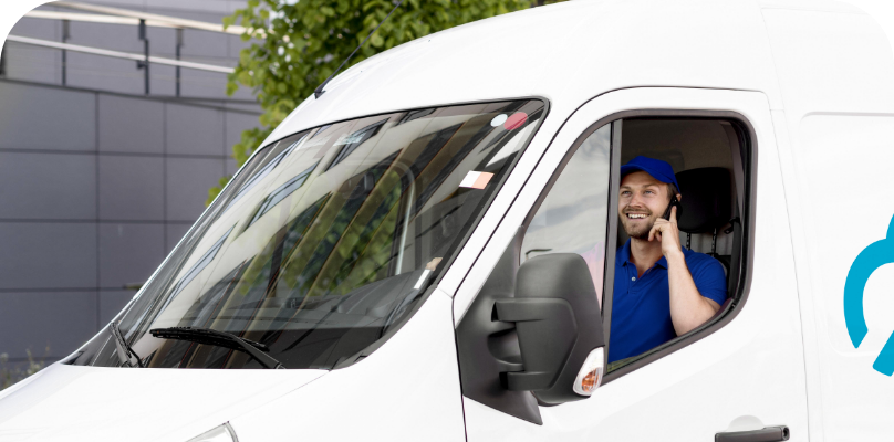 Ein Skyber-Mitarbeiter sitzt lächelnd auf dem Fahrersitz eines weißen Lieferwagens.