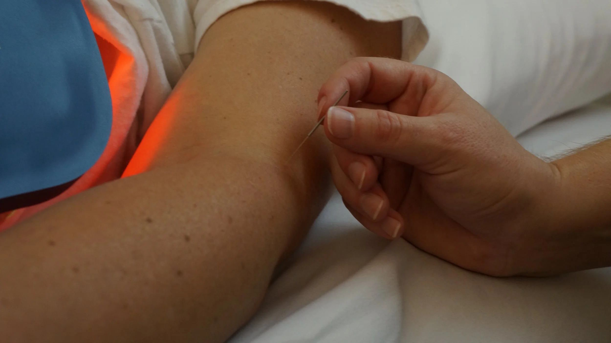 Brittany manipulating a needle and Celluma Low-Level Light Therapy