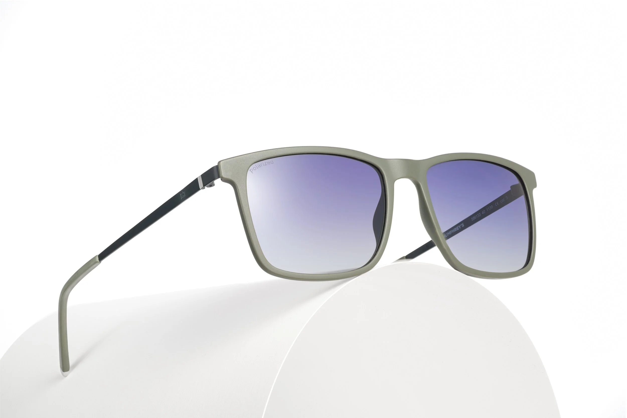 Minimal sunglasses product photography on white surface with soft studio lighting