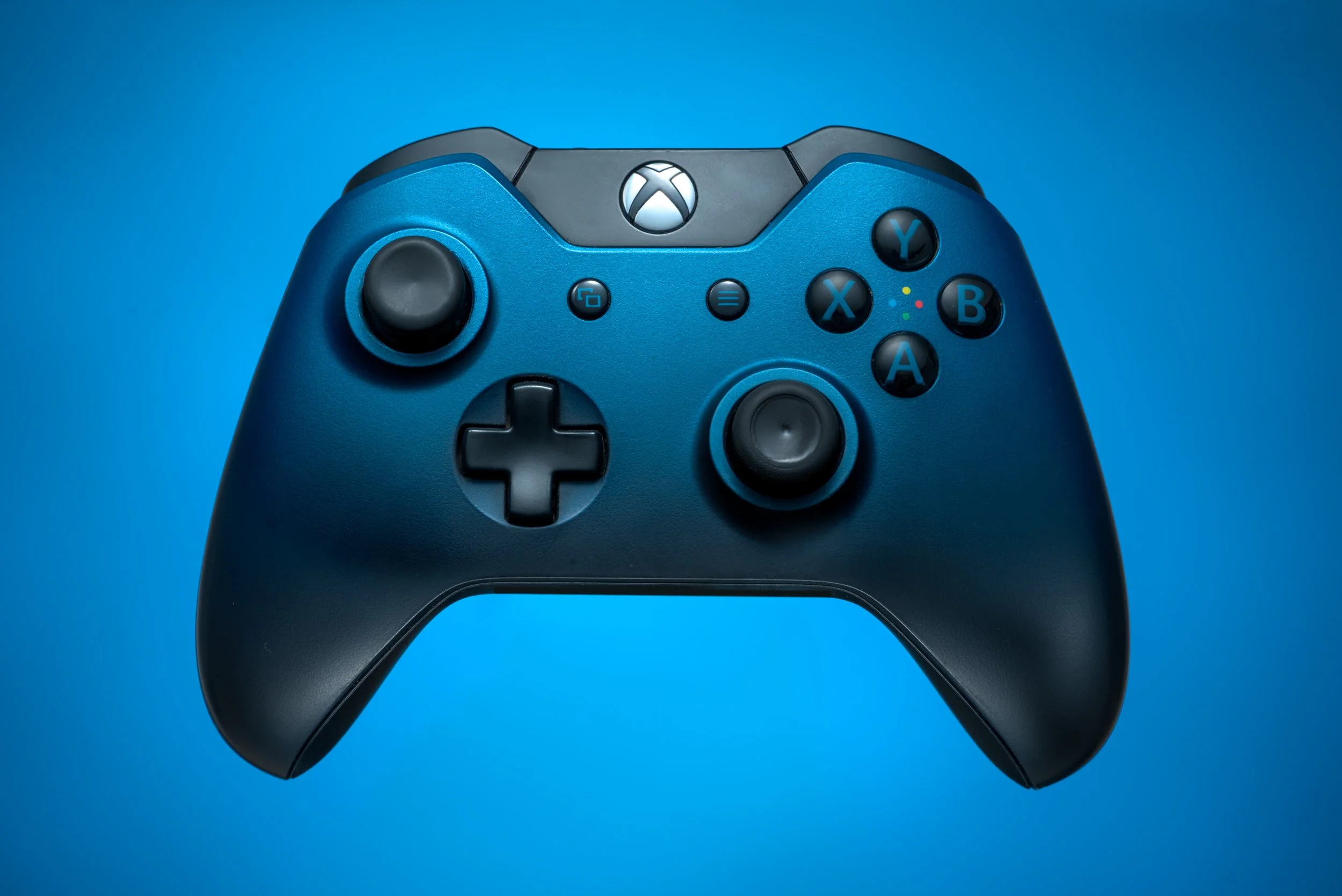 Blue xbox gaming controller product photography with clean gradient background and studio lighting