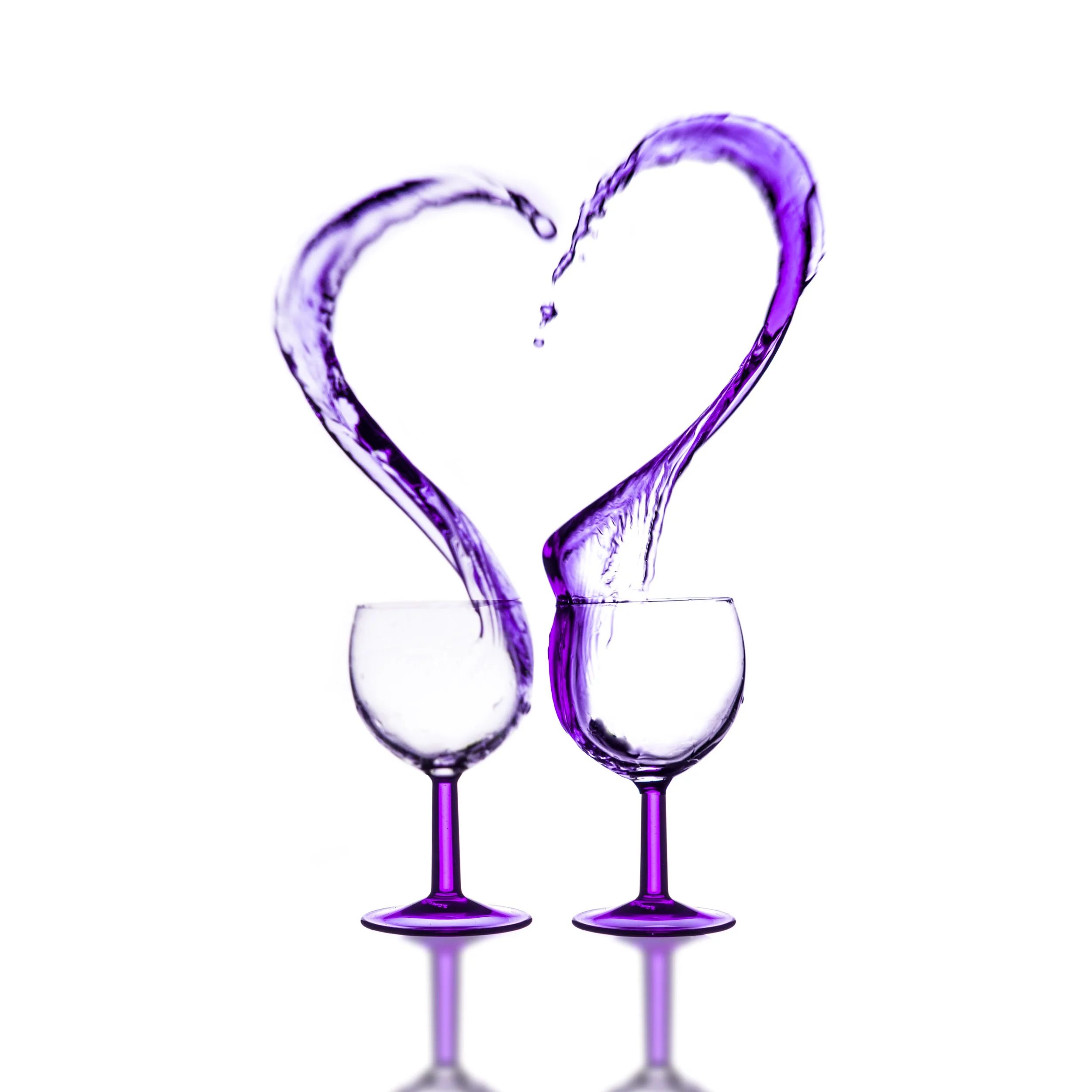 Two wine glasses with purple-tinted stems, with purple liquid forming a heart shape between them, against a white background.