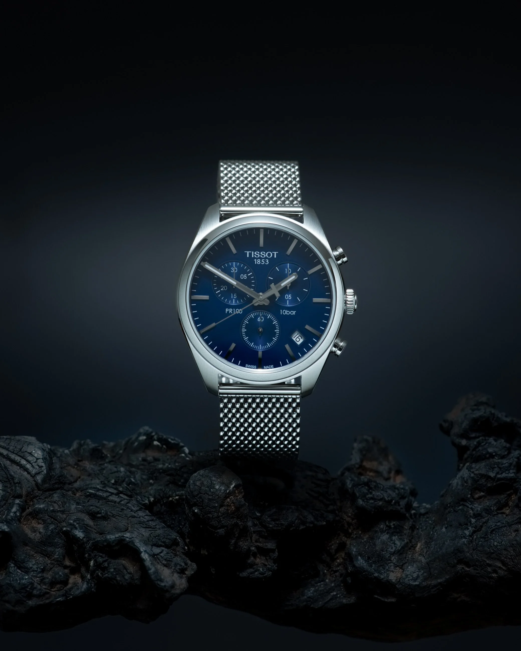 Luxury wristwatch product photography on dark wood with dramatic studio lighting