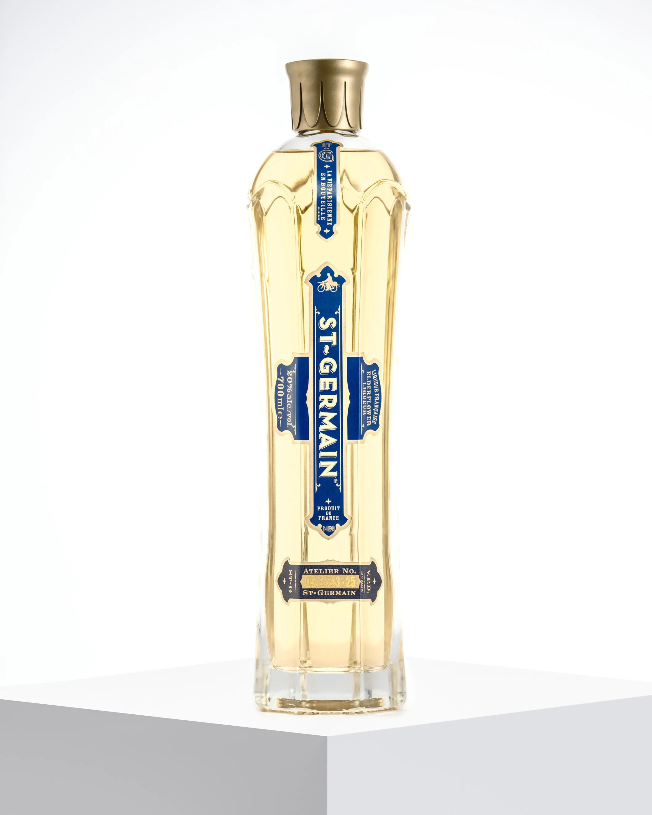 Liquor bottle product photography on white pedestal with soft studio lighting