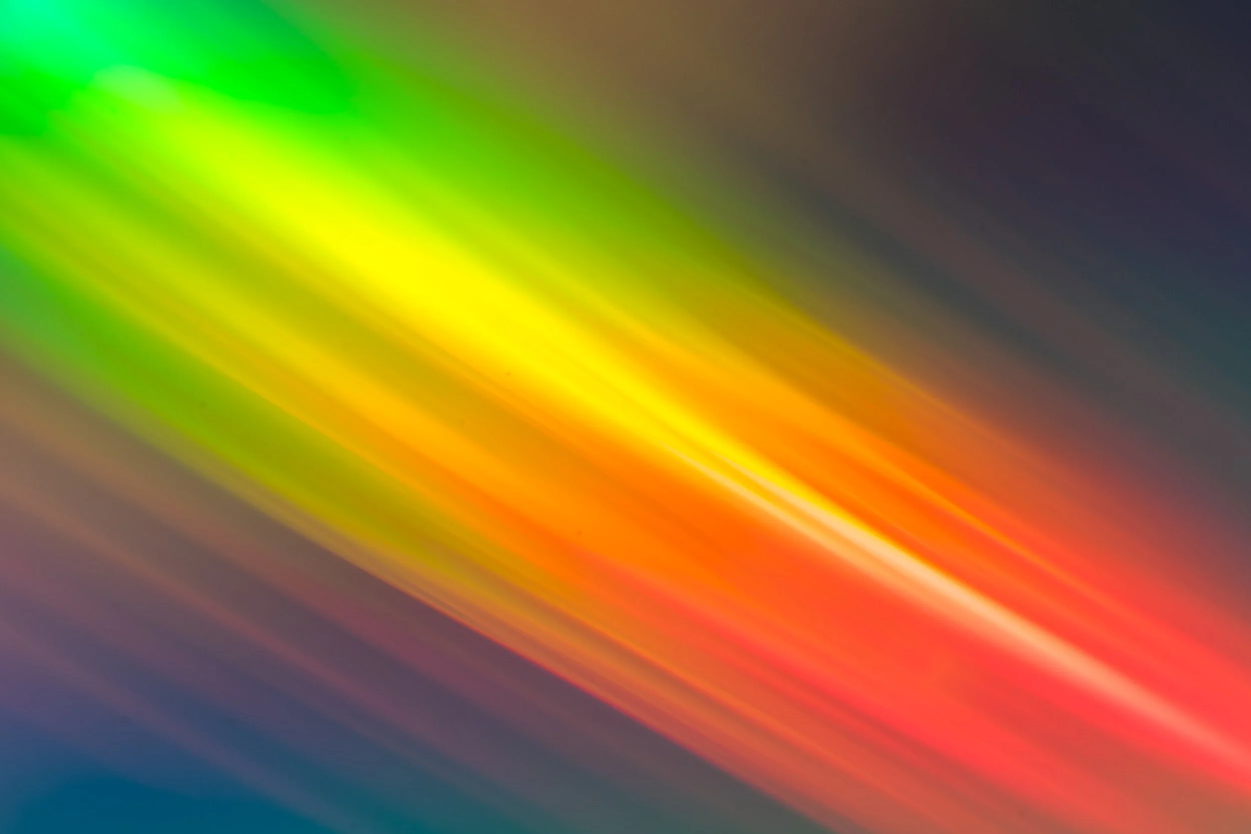 Blurred multicolor light streaks with shades of green, yellow, orange, red, and blue.
