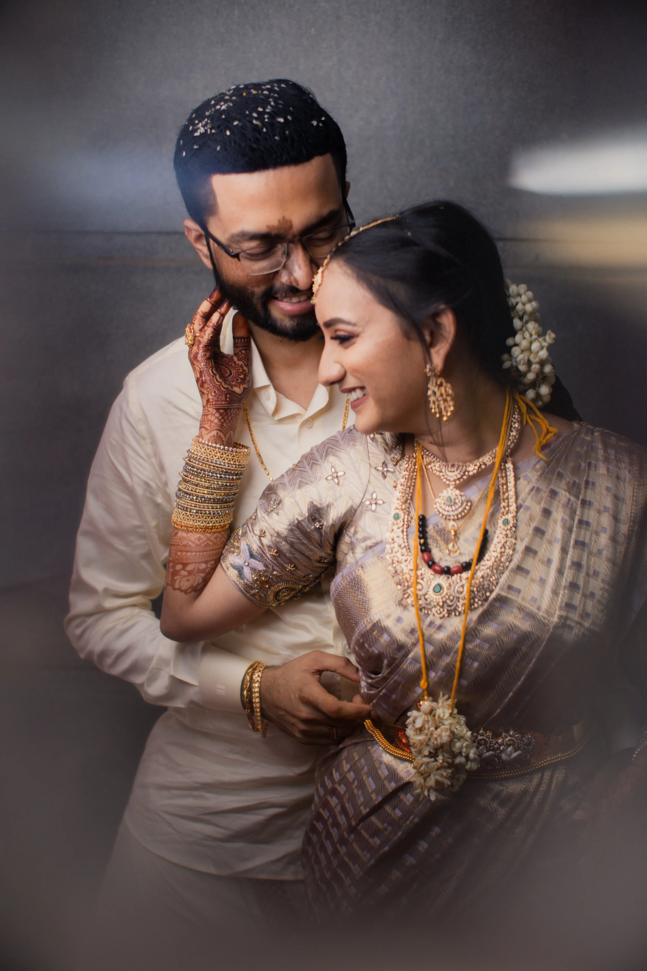 A couple dressed in traditional Indian attire sharing a moment of affection.