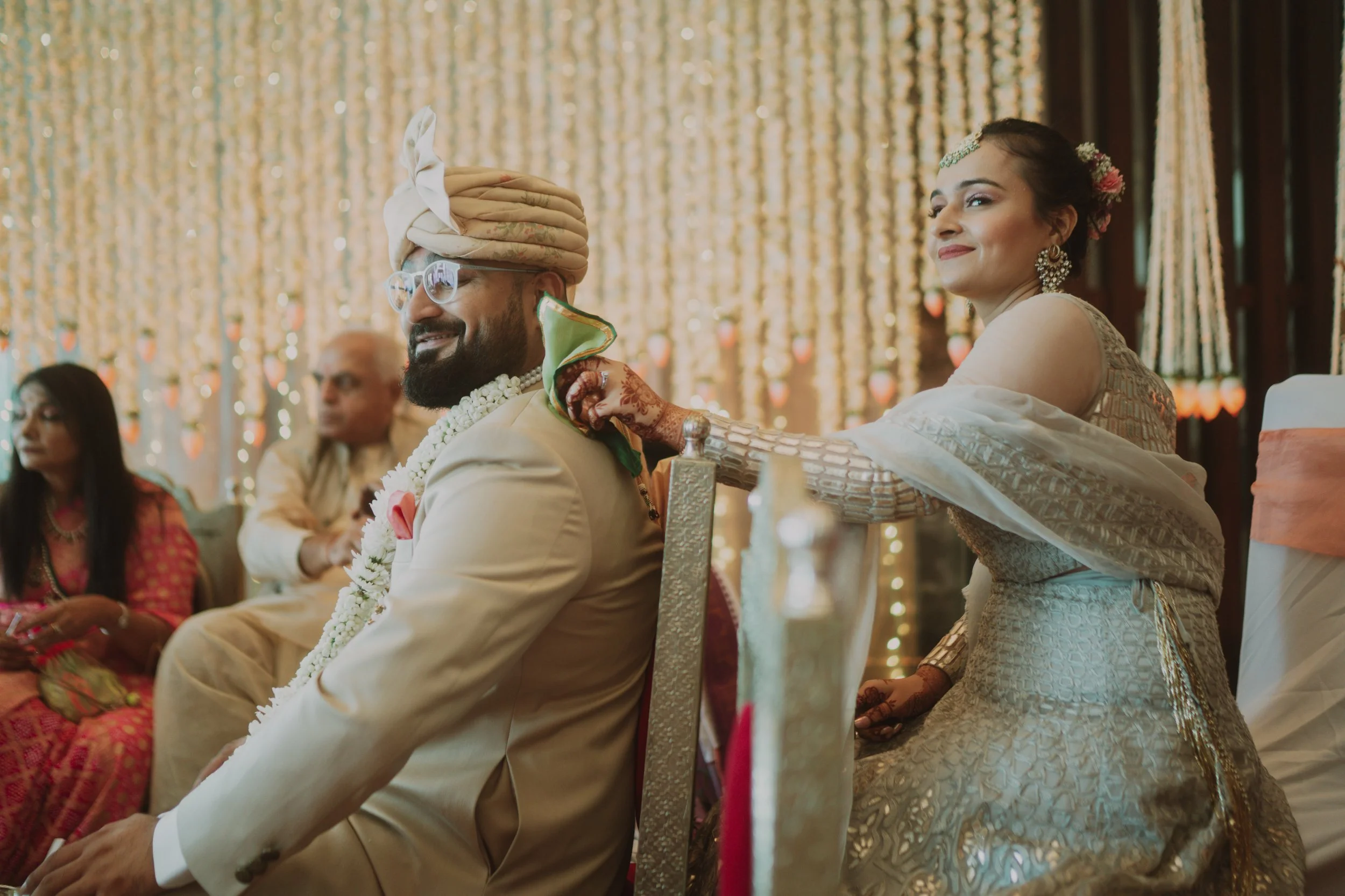 Indian bride applying sindoor on groom's forehead during wedding ceremony.