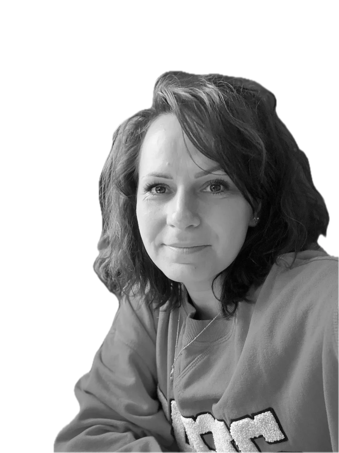 Black-and-white portrait of a woman with shoulder-length wavy hair, wearing a sweatshirt and a necklace, looking directly at the camera with a slight smile.