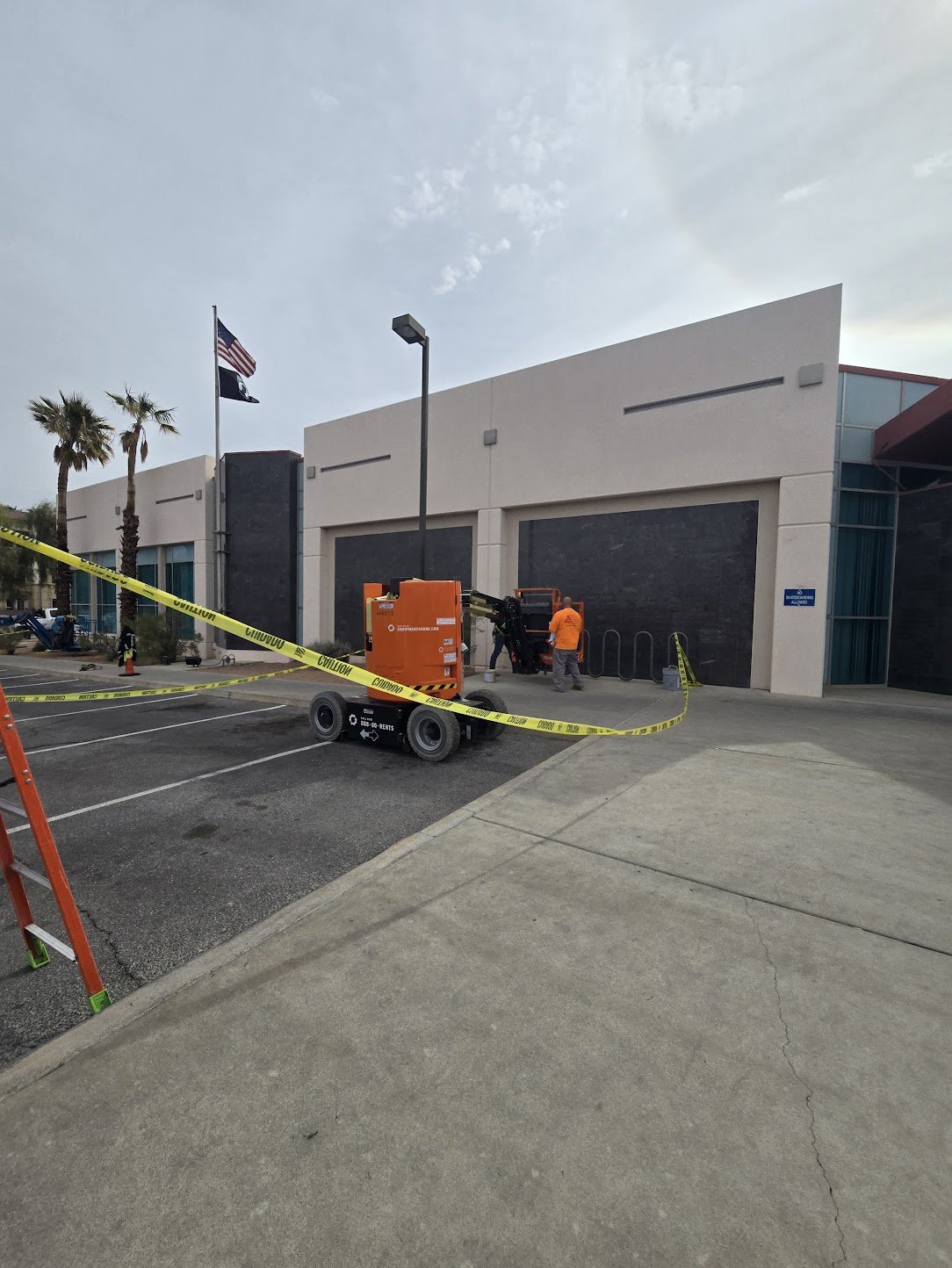 Caulkers operating equipment outside a building, sealing it with caulking.
