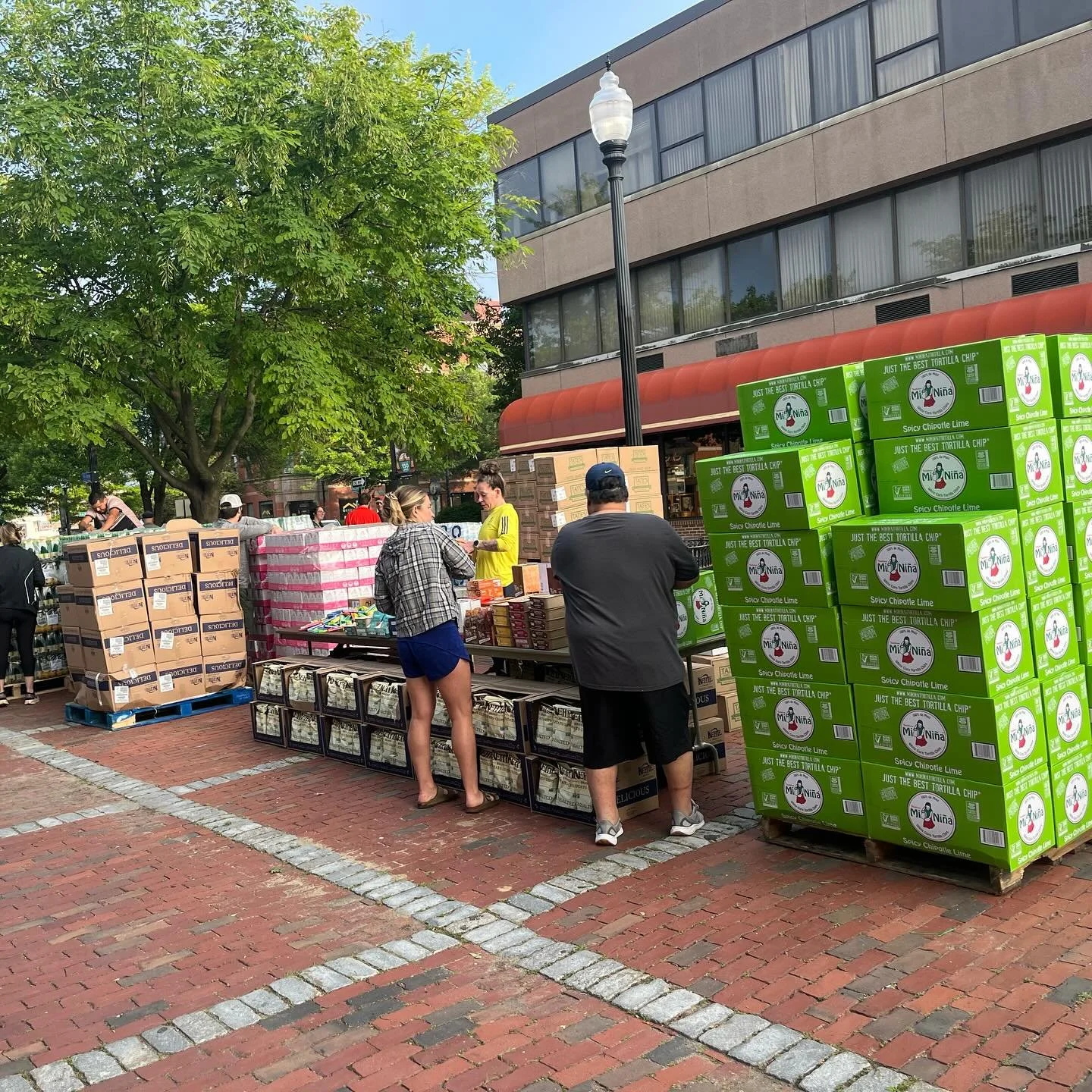 Volunteers prep and hand out donated food and gift bags.