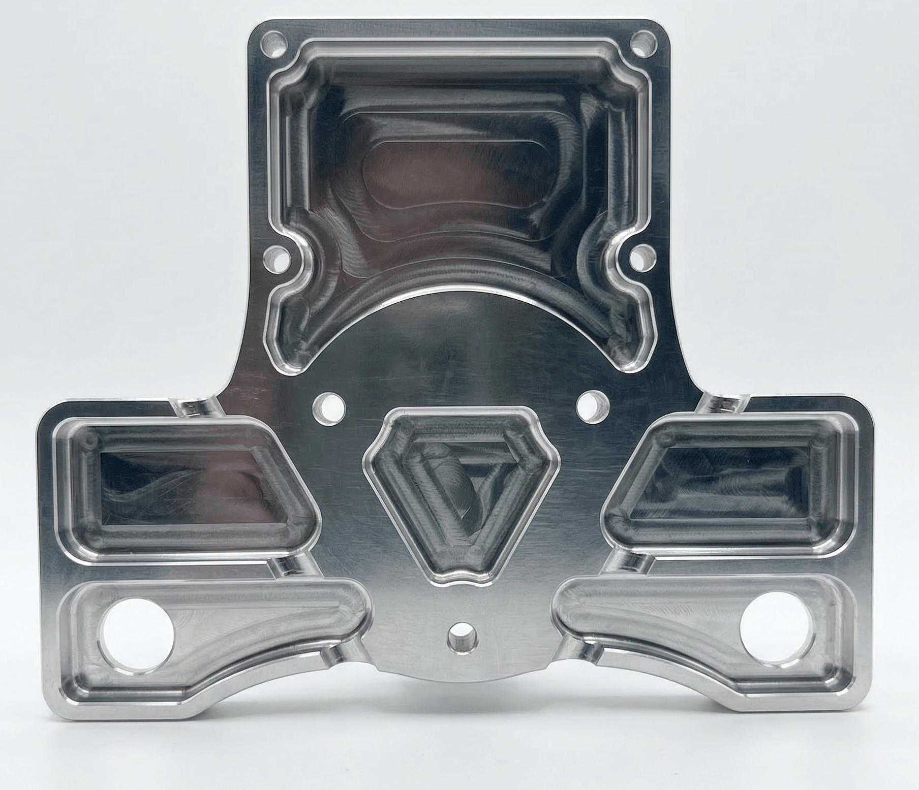 A metallic, precision-machined plastic injection mold with various hollowed-out sections and holes, used for manufacturing plastic parts.