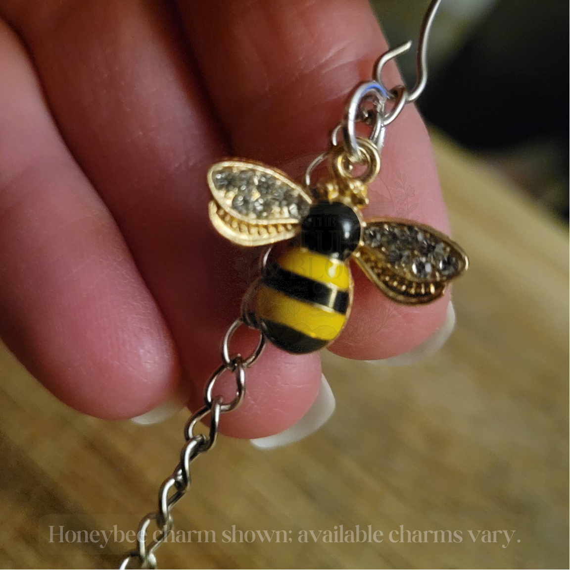 Honeybee charm shown; available charms vary..png