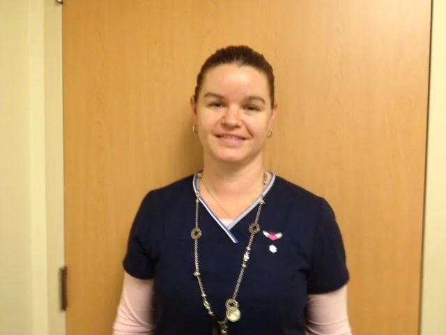 A smiling woman in medical scrubs