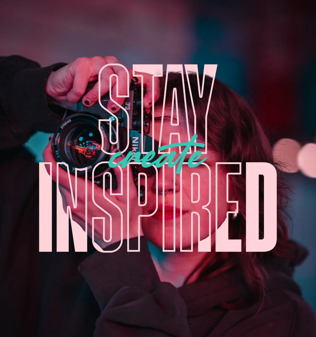 Person with dark hair holding a camera up to their face, with overlaid motivational text saying 'Stay Inspired' and 'Create'.