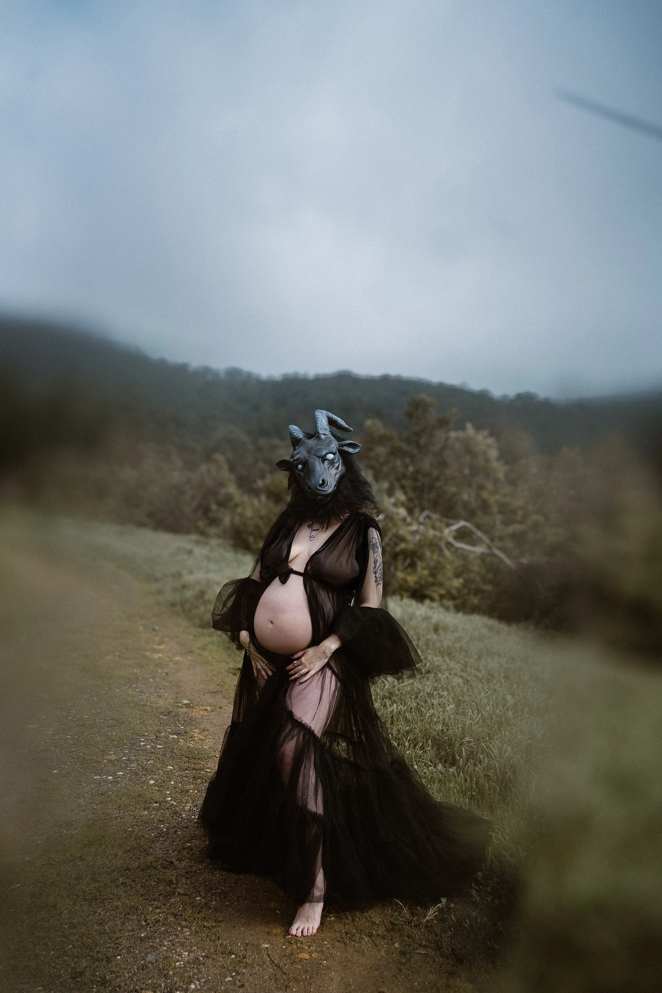 Artistic outdoor maternity photoshoot in nature featuring a pregnant woman in dramatic styling in Portugal.