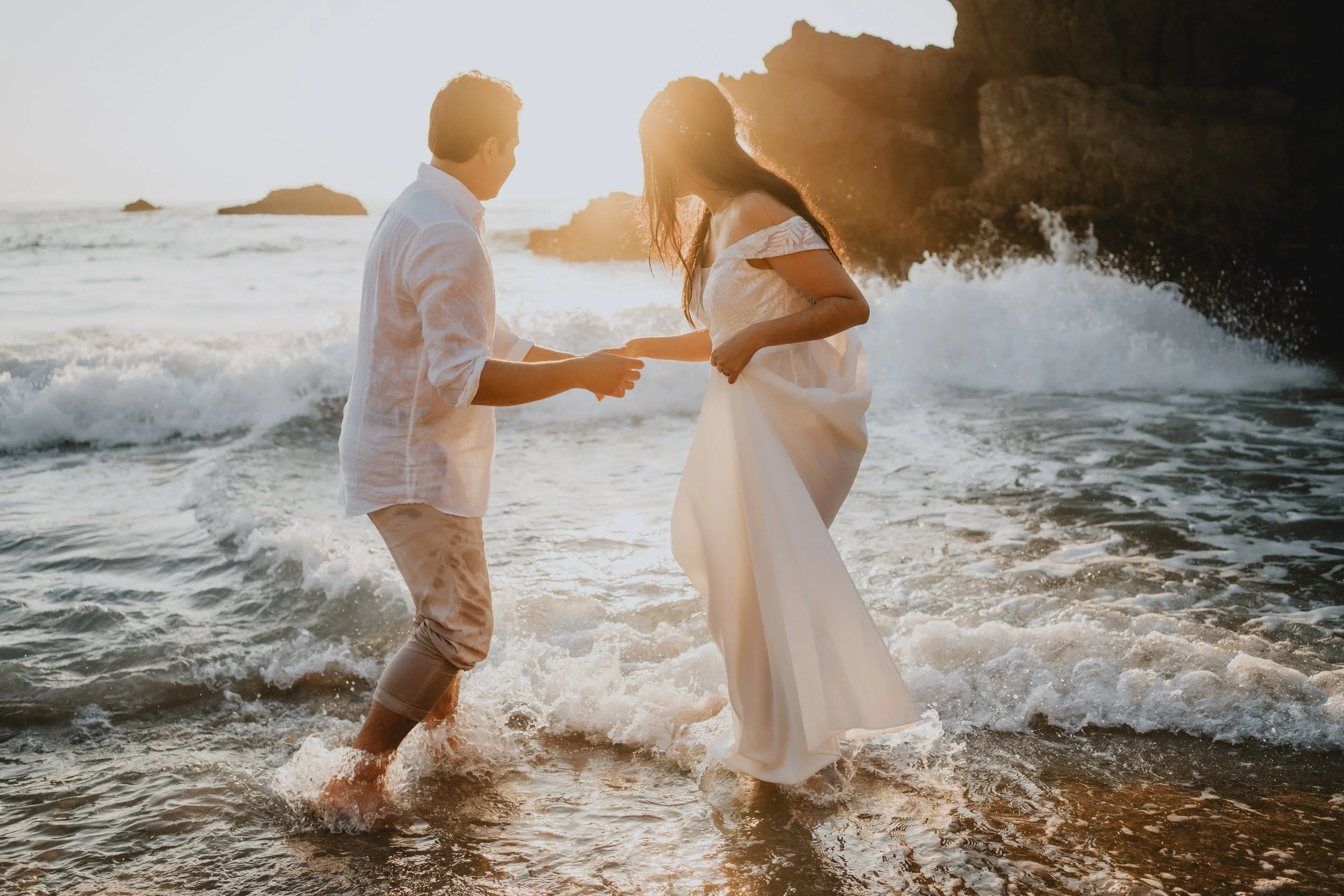 Adventure elopement couple running barefoot on Adraga Beach at sunset in Sintra Portugal