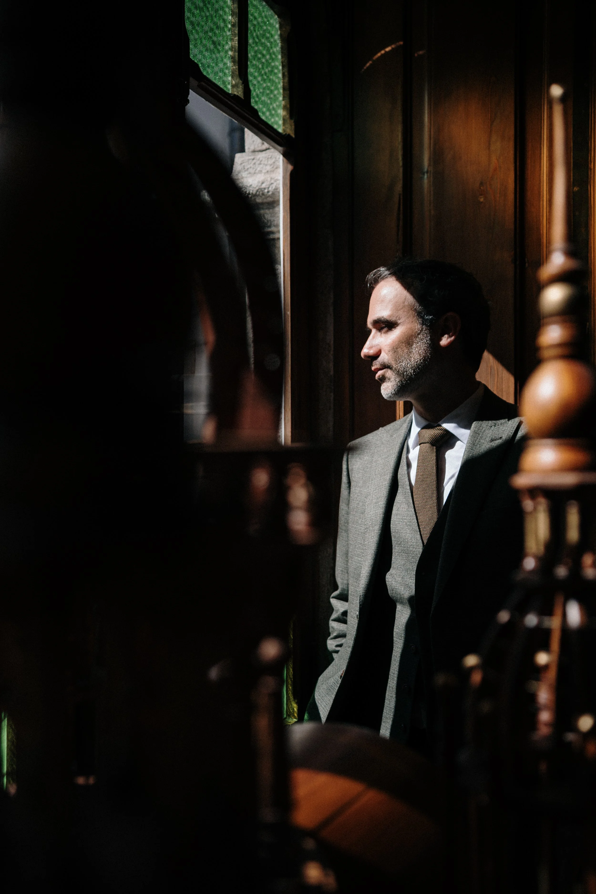 Editorial groom portrait in dramatic natural light during destination wedding in Portugal