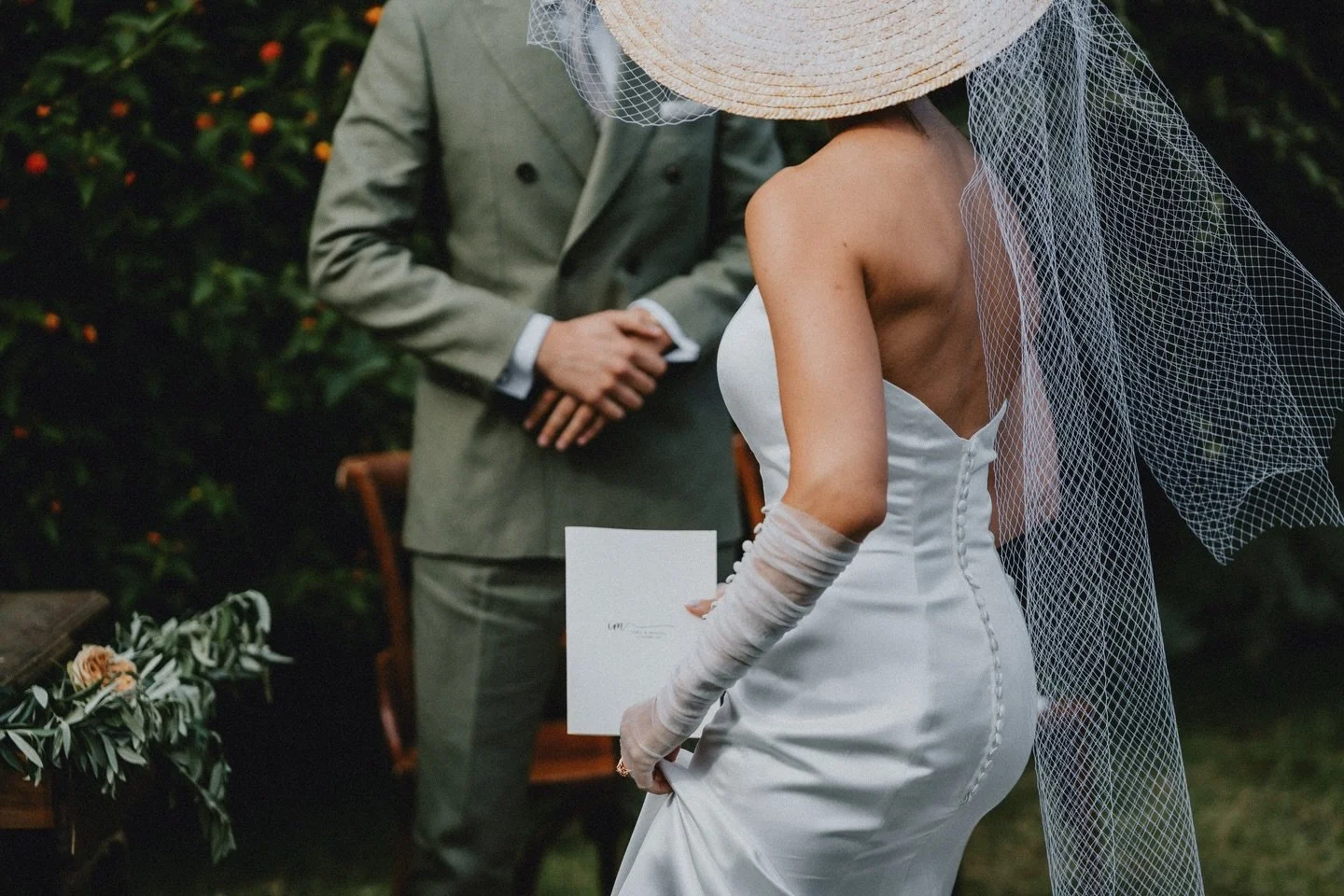 Every detail carried intention.
The quiet rustle of fabric,
the softness of gloves against paper,
the weight of words held close to the heart.

A dress that speaks in silence,
buttons tracing a spine like punctuation,
a veil that drifts like an unfin