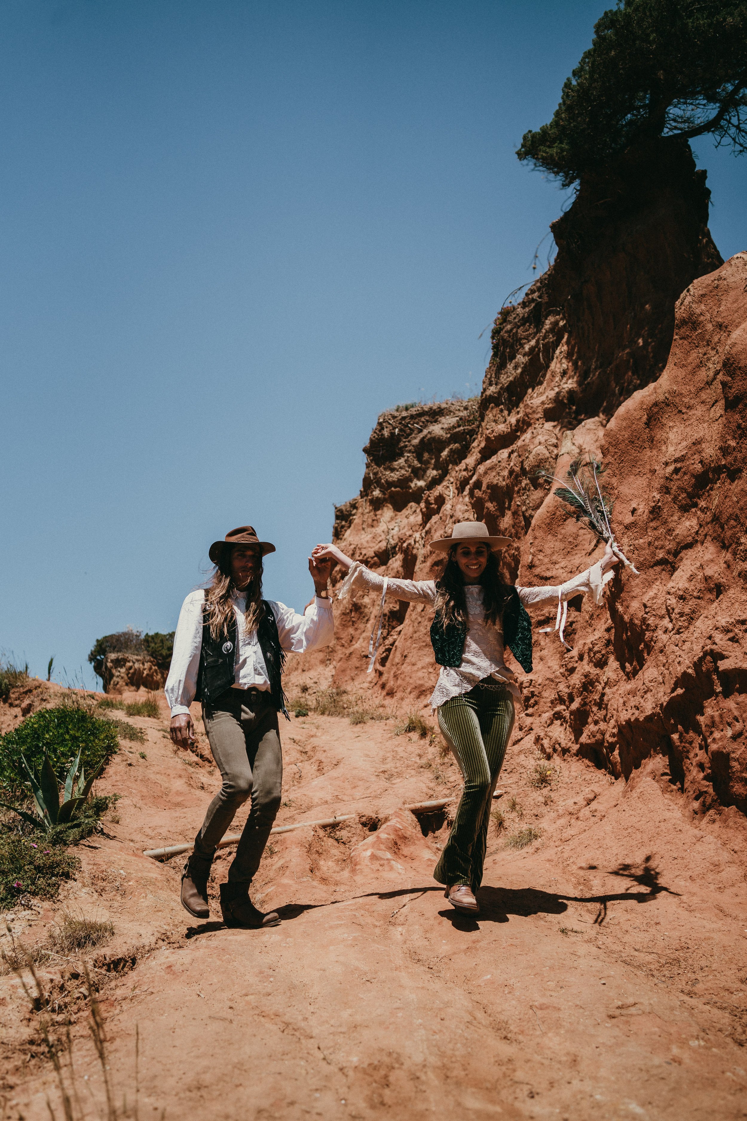 Couple walking through dramatic cliffs during destination elopement in Portugal