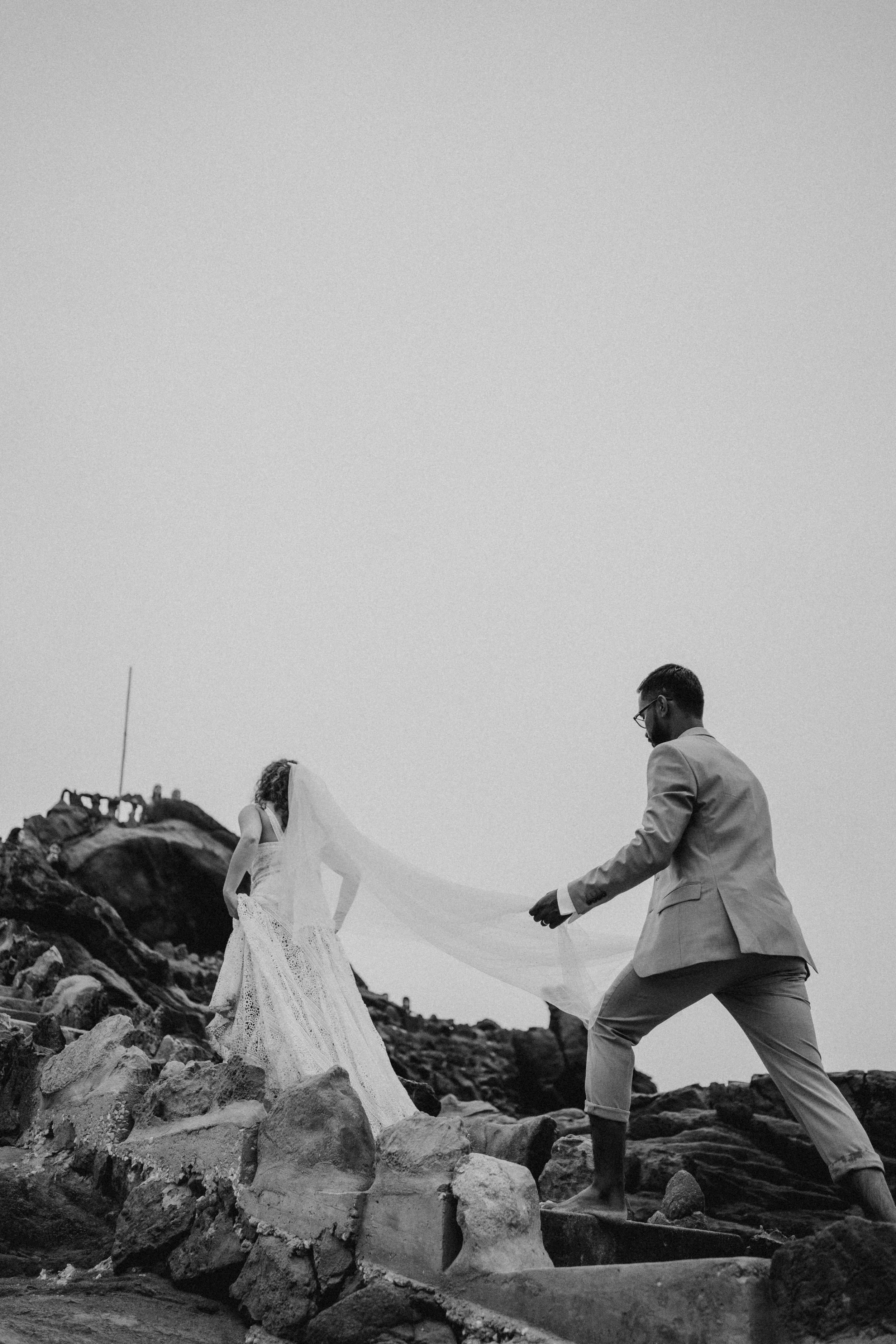 Dramatic black and white wedding portrait on staircase with cinematic lighting