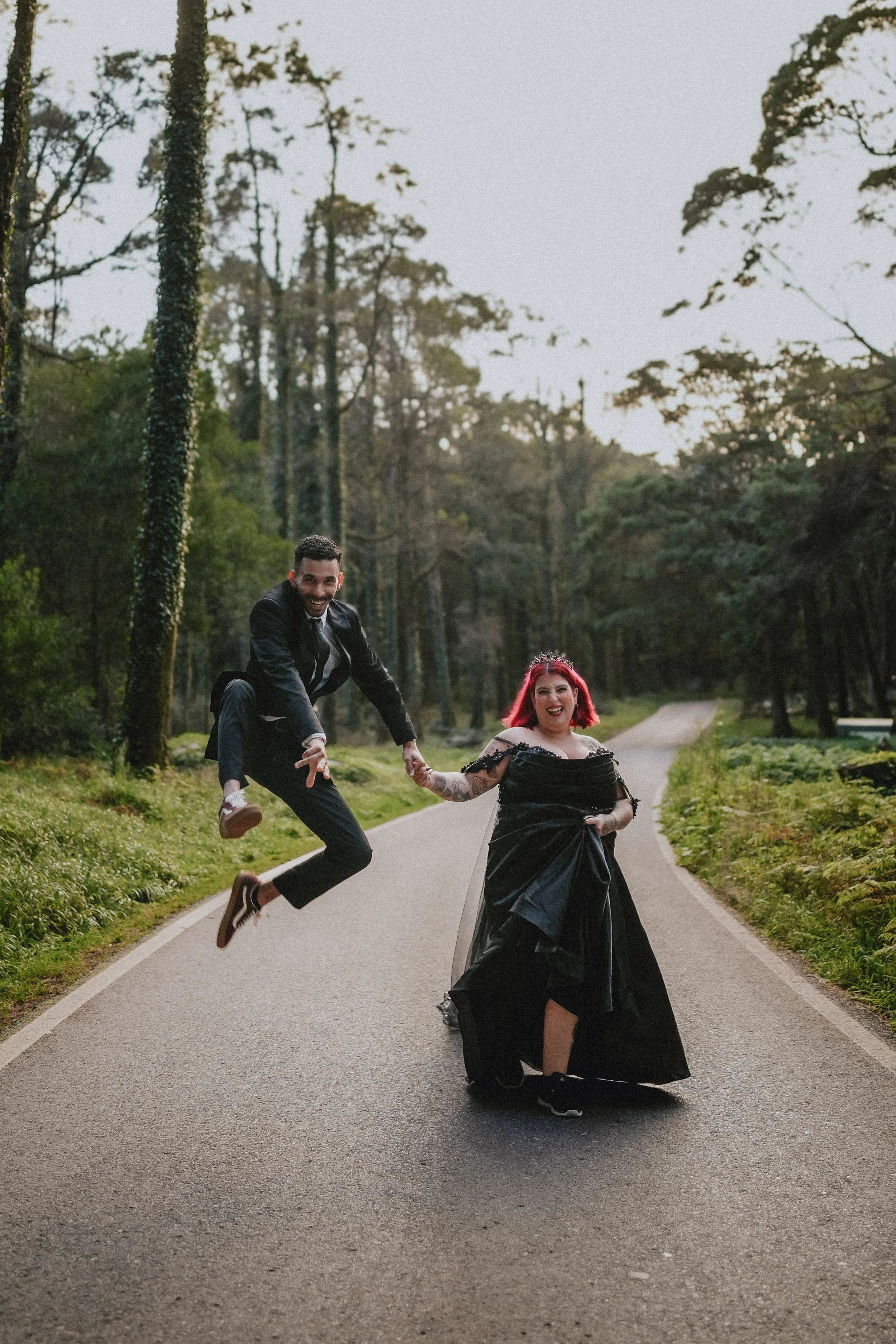 Moody alternative wedding portrait of bride in black dress in Portuguese forest