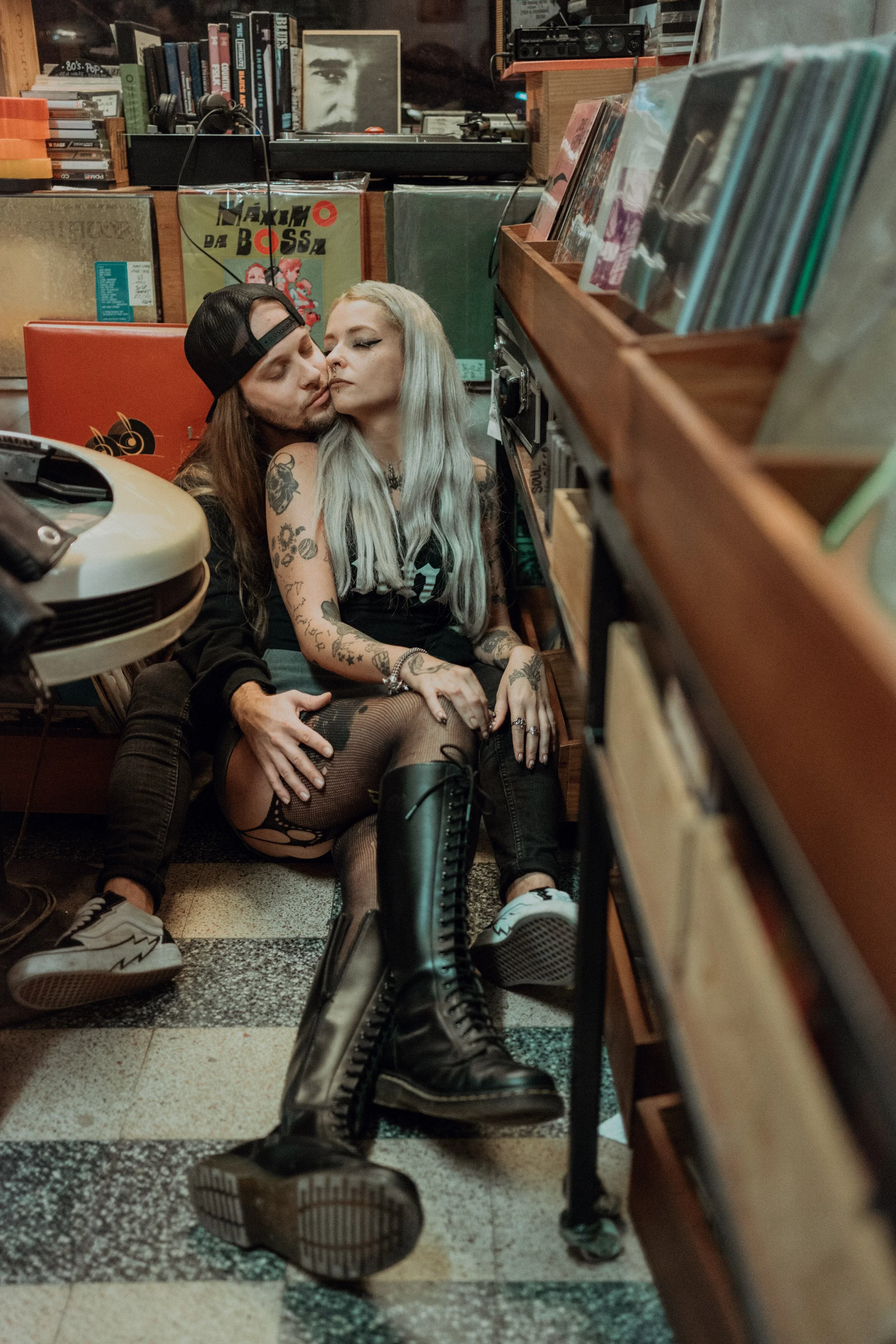 Alternative engagement photography in Lisbon, couple sharing intimate moment inside vintage record store.
