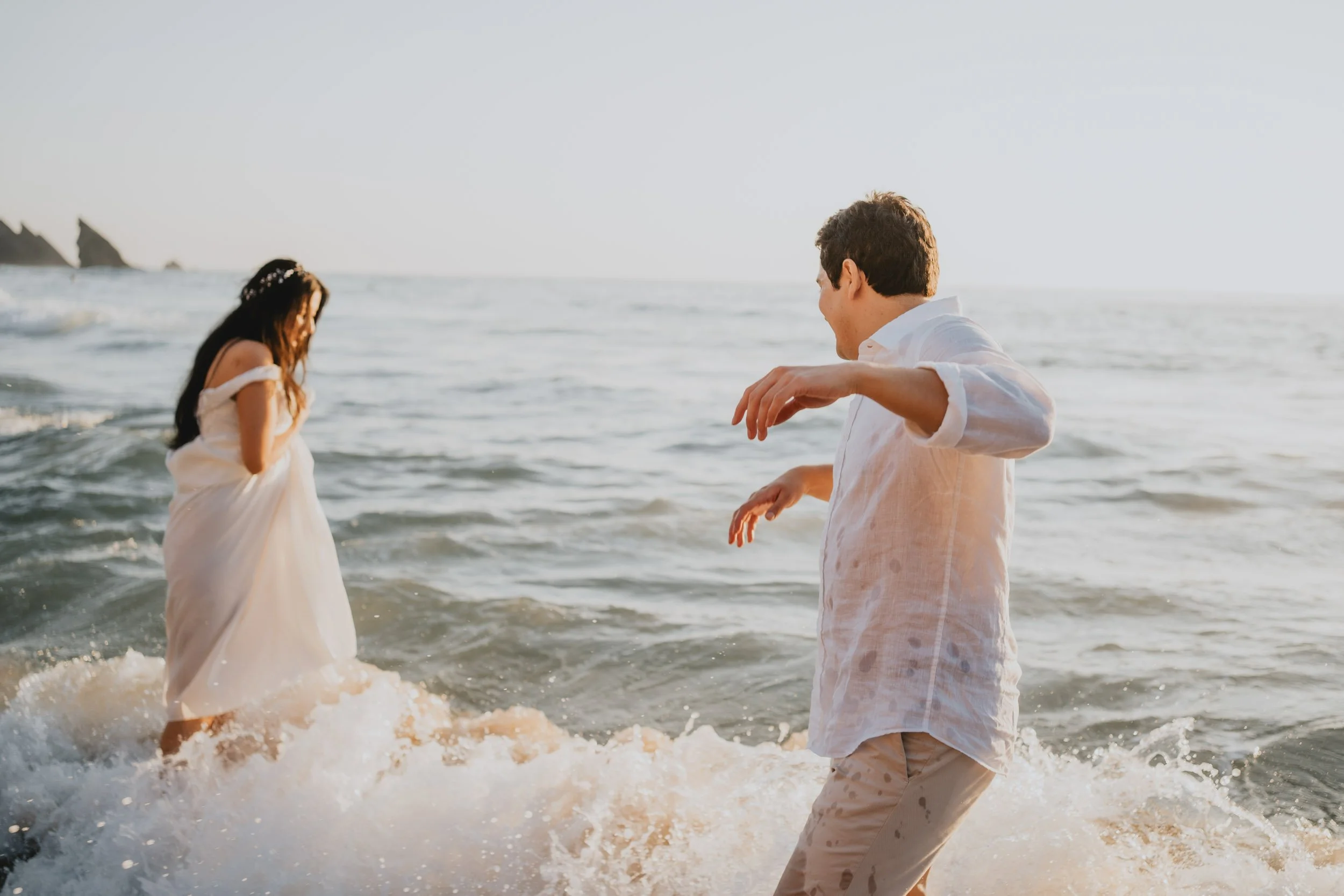 Adventure elopement couple having fun in the ocean in Adraga beach