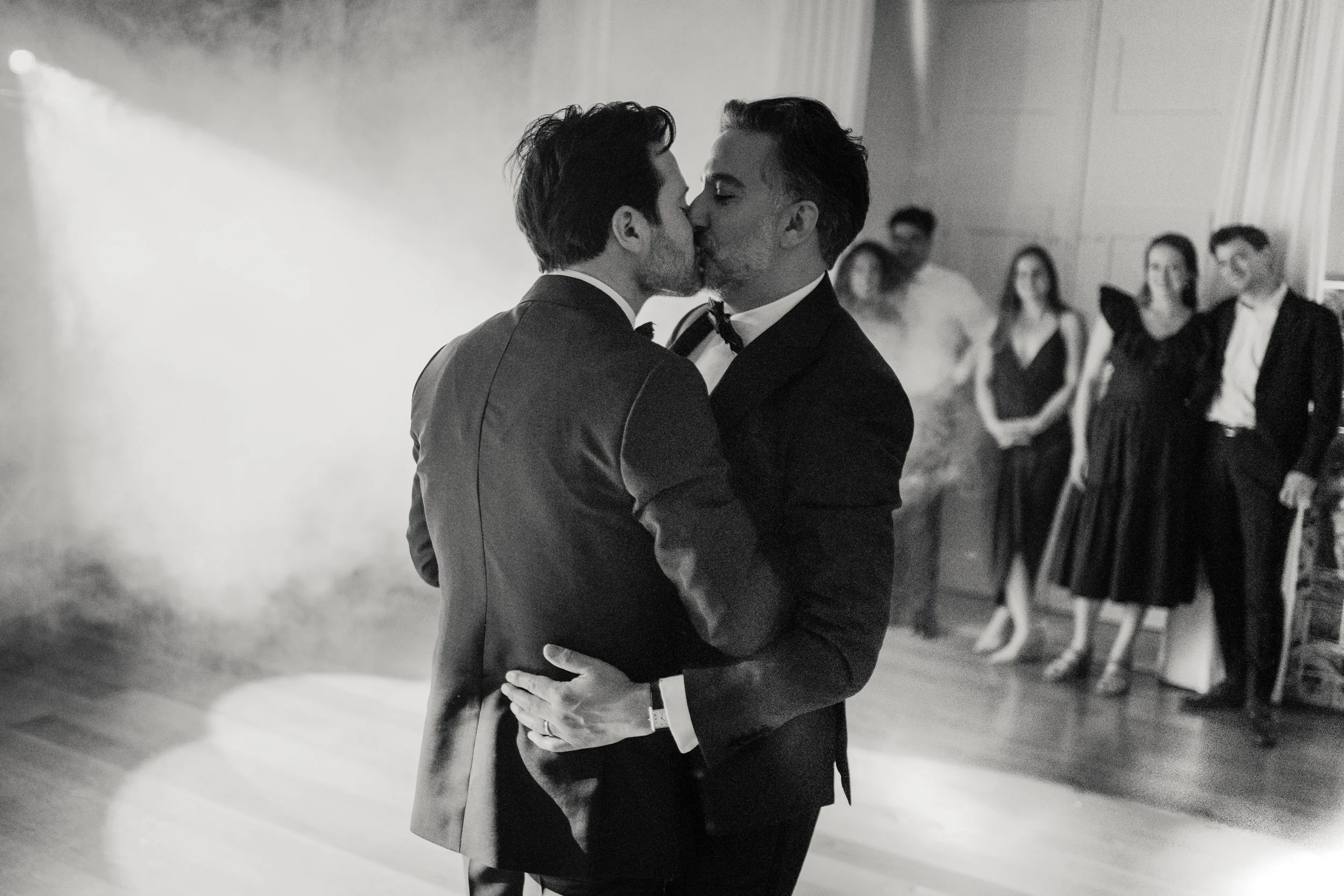 Intimate black and white wedding portrait of two grooms embracing during their Lisbon wedding