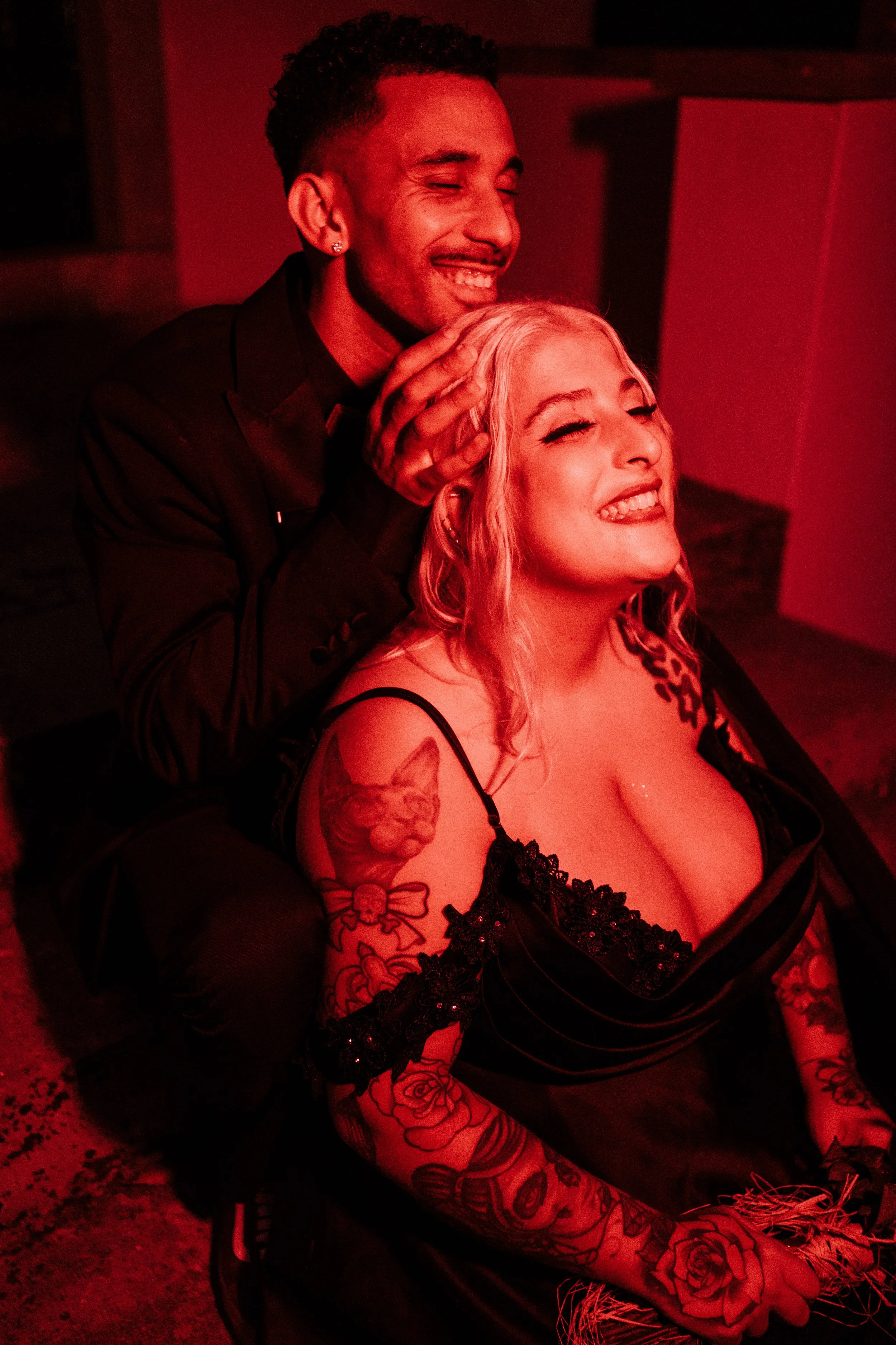 Bold alternative wedding portrait with dramatic red lighting 