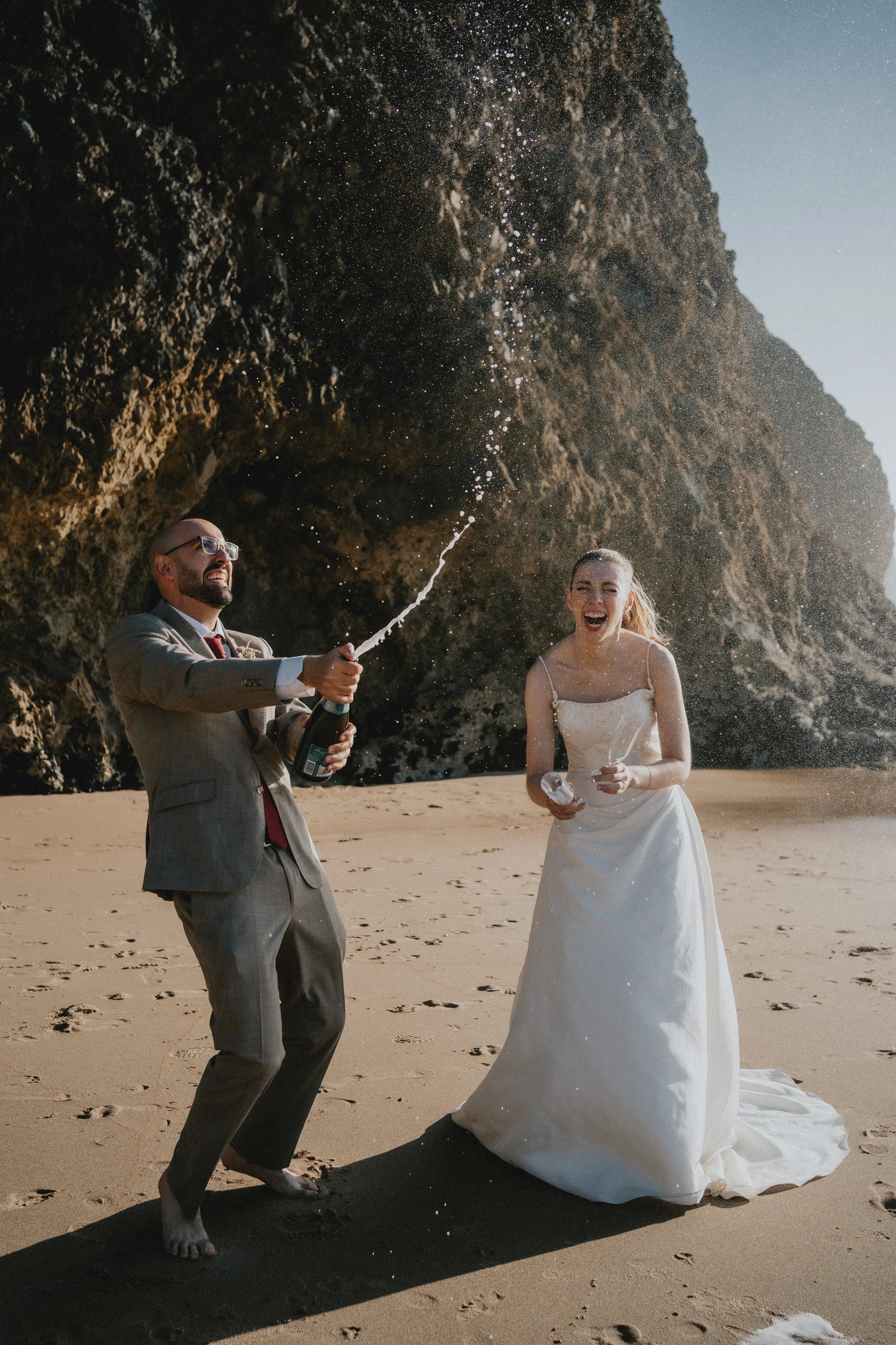 Couple celebrating their elopement in Portugal with champagne at golden hour
